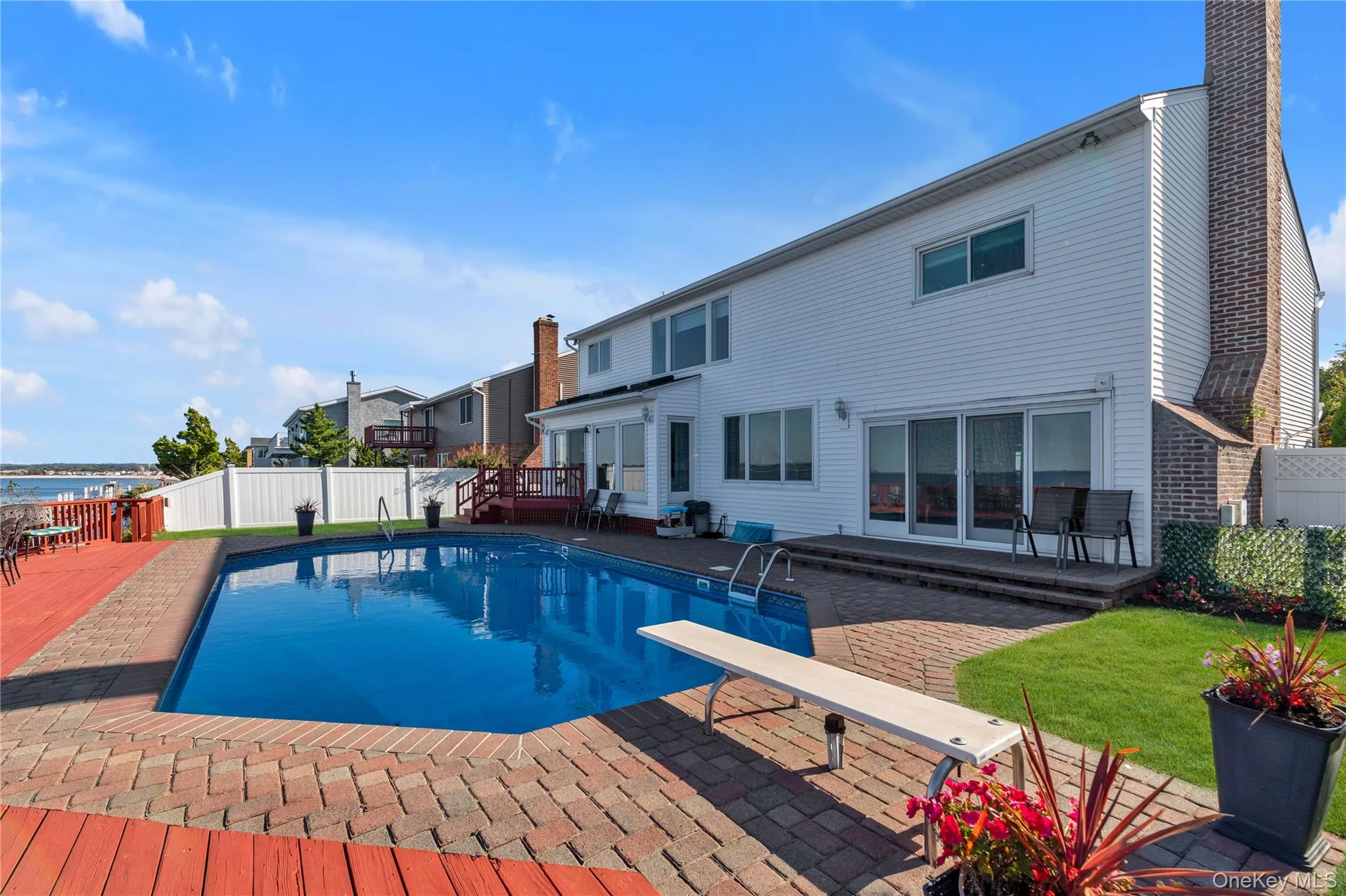 View of swimming pool with a patio, a fenced backyard, a diving board, and a deck View of swimming pool with a patio, a fenced backyard, a diving board, and a deck