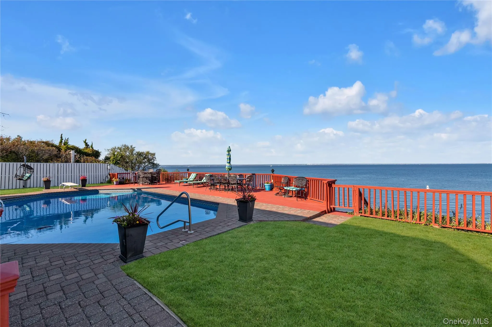 View of swimming pool featuring a water view and a fenced backyard View of swimming pool featuring a water view and a fenced backyard