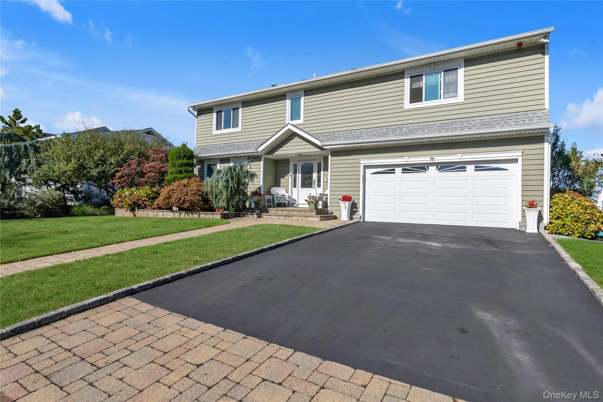 Traditional home with a front lawn, an attached garage, and asphalt driveway Traditional home with a front lawn, an attached garage, and asphalt driveway