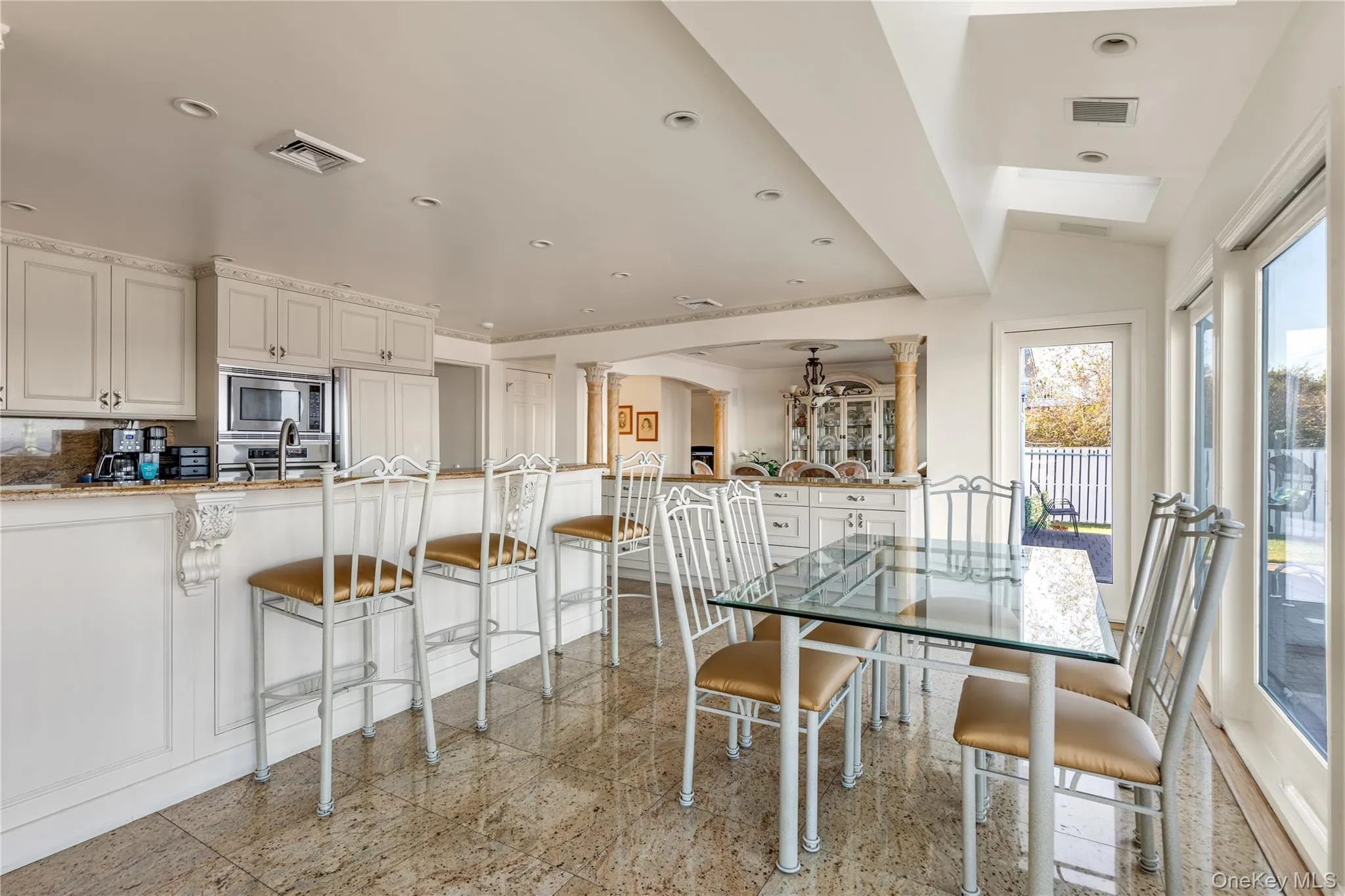 Dining room featuring granite floors, decorative columns, recessed lighting, arched walkways, and a chandelier Dining room featuring granite floors, decorative columns, recessed lighting, arched walkways, and a chandelier