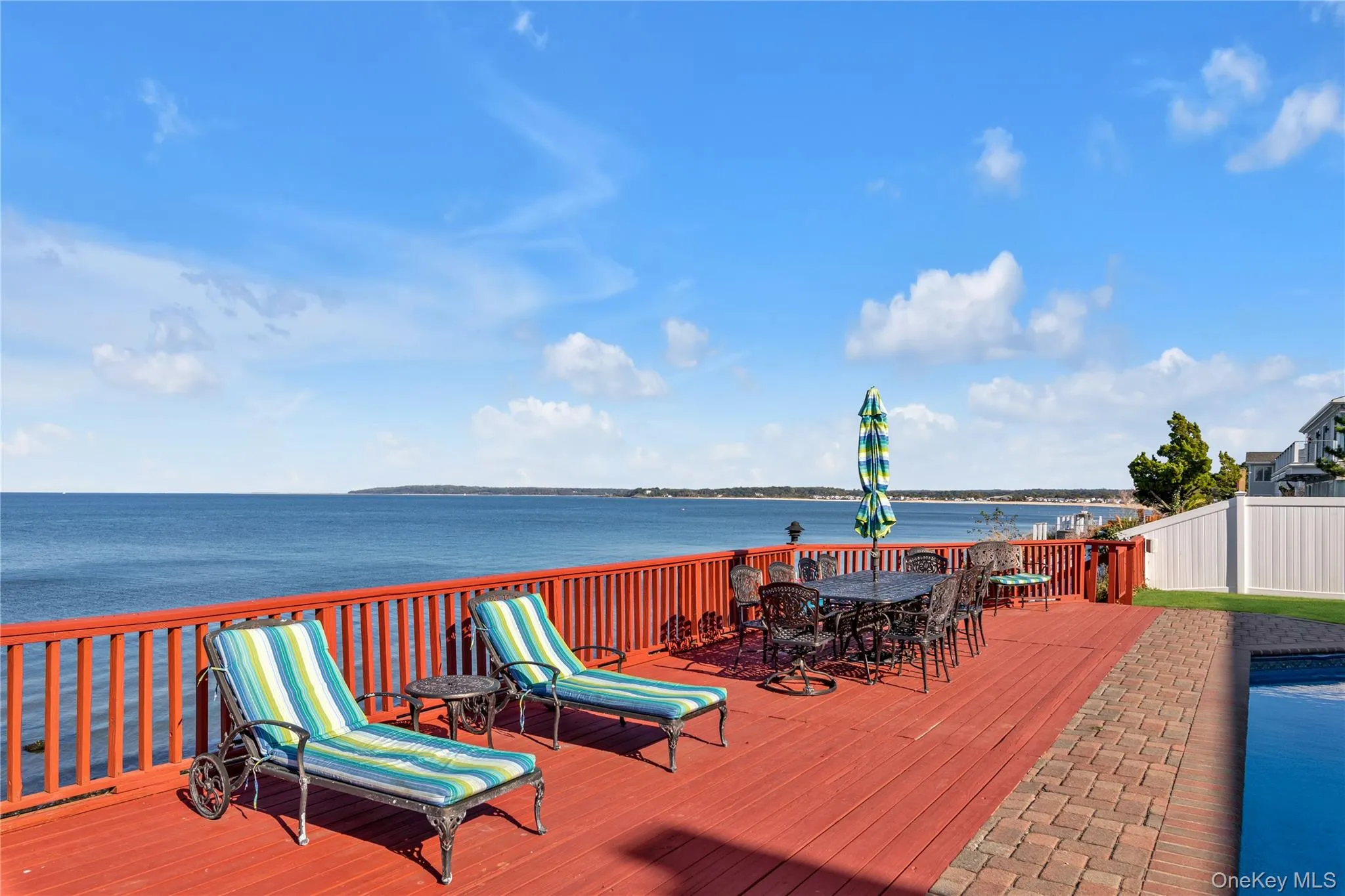 Wooden terrace with a water view and outdoor dining area Wooden terrace with a water view and outdoor dining area