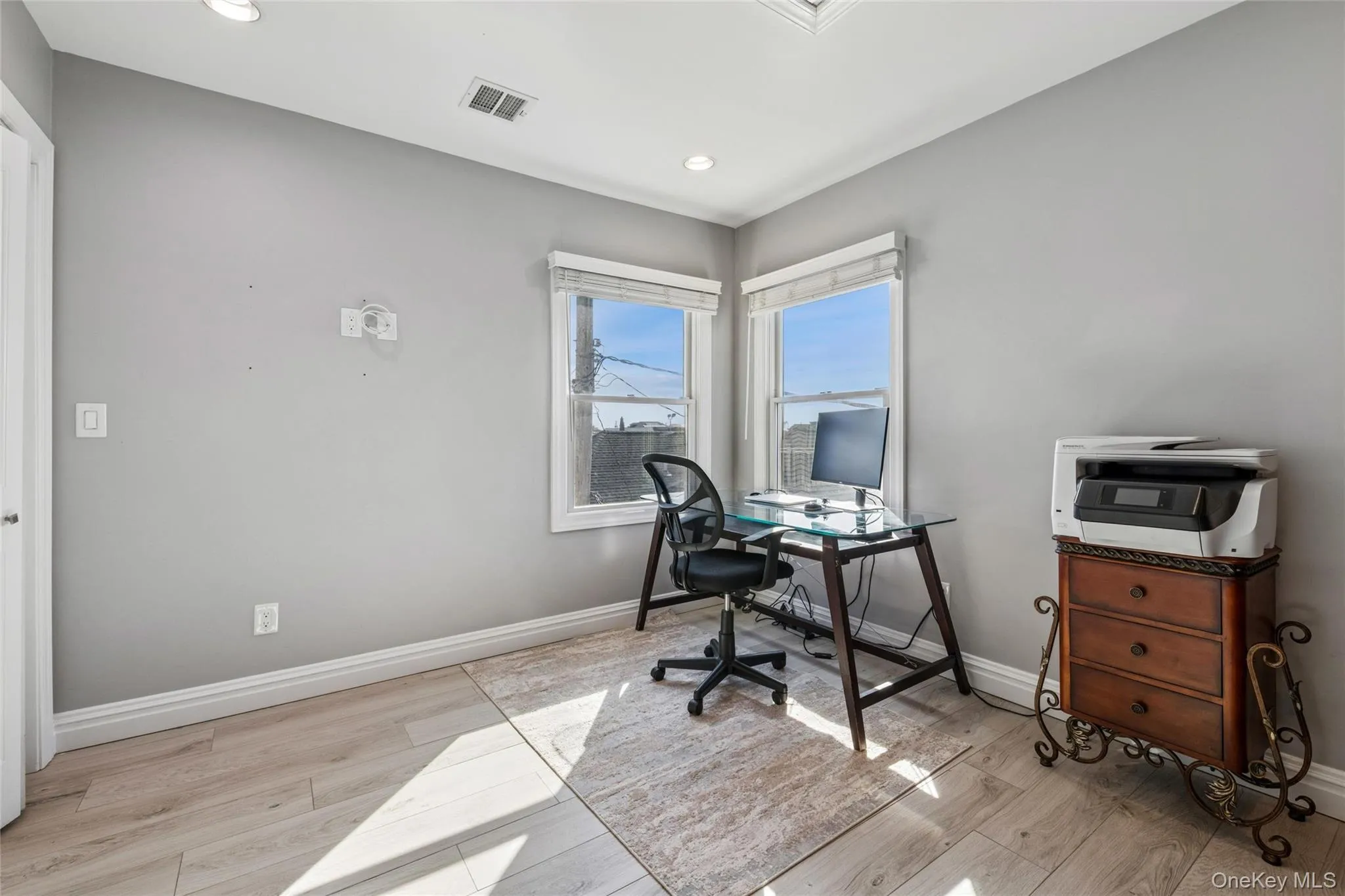 Office area with light wood-style floors and recessed lighting Office area with light wood-style floors and recessed lighting