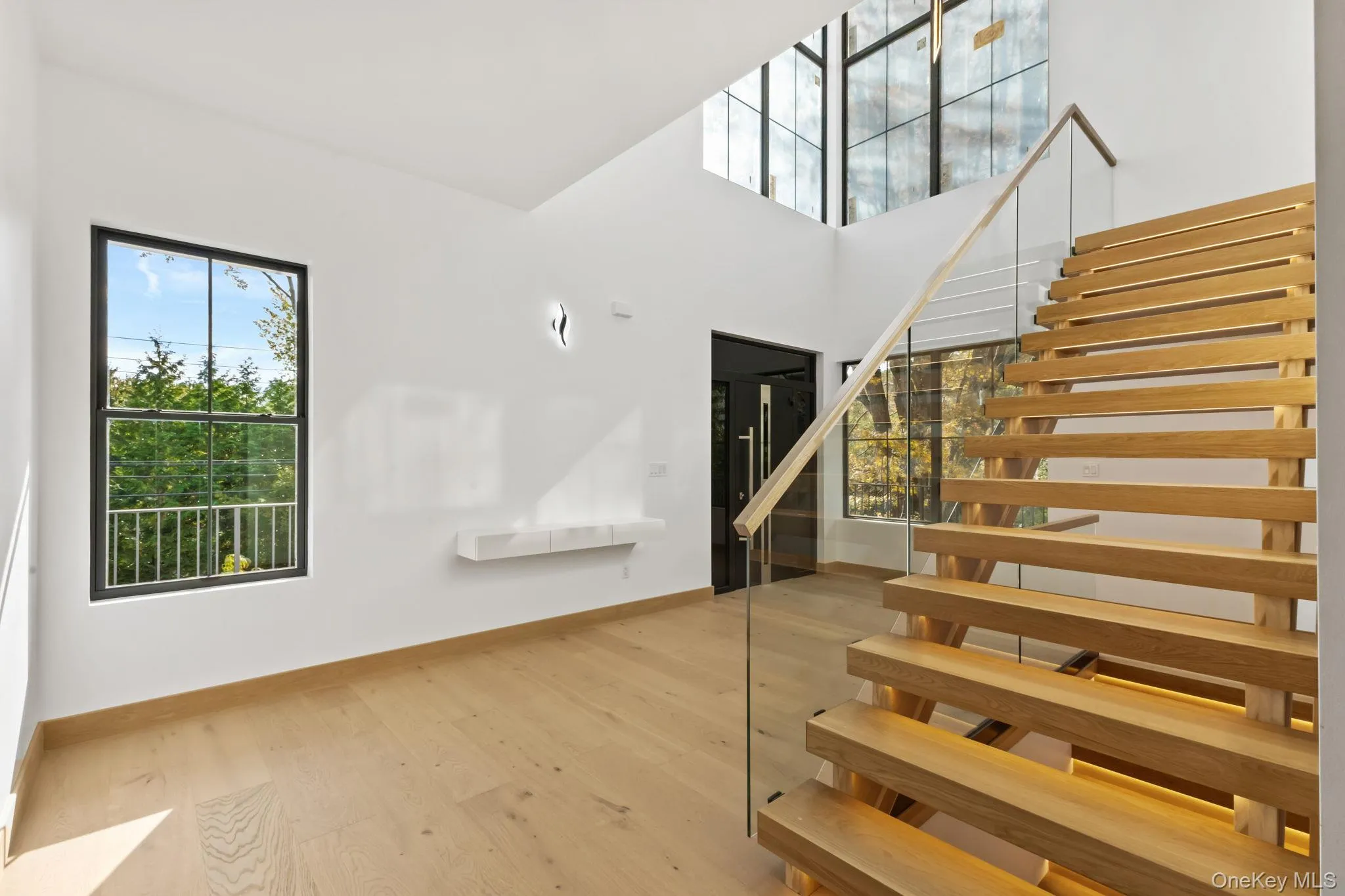 Stairway featuring wood finished floors and a high ceiling Stairway featuring wood finished floors and a high ceiling