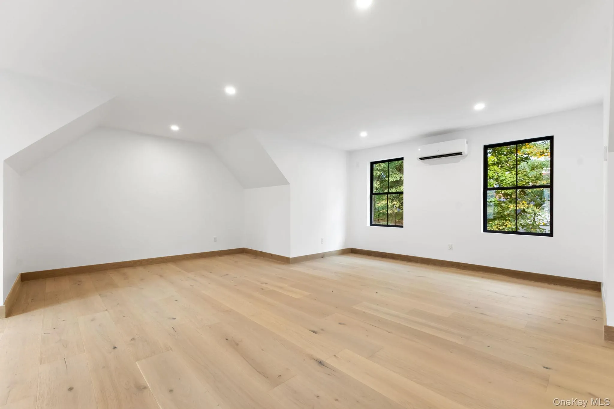Bonus room featuring light wood finished floors, recessed lighting, and a wall mounted air conditioner Bonus room featuring light wood finished floors, recessed lighting, and a wall mounted air conditioner