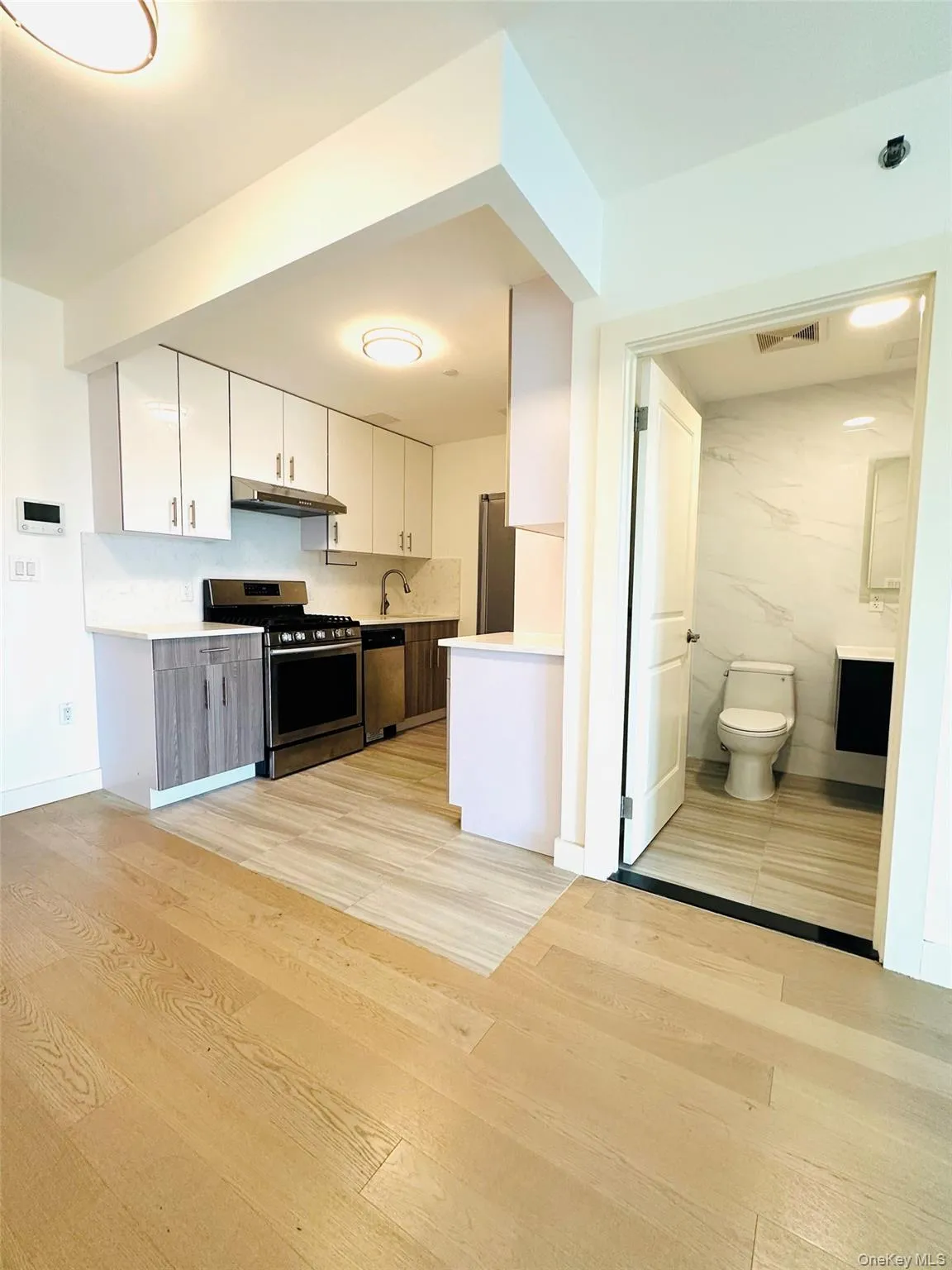 Kitchen with white cabinetry, light countertops, appliances with stainless steel finishes, and light wood finished floors Kitchen with white cabinetry, light countertops, appliances with stainless steel finishes, and light wood finished floors
