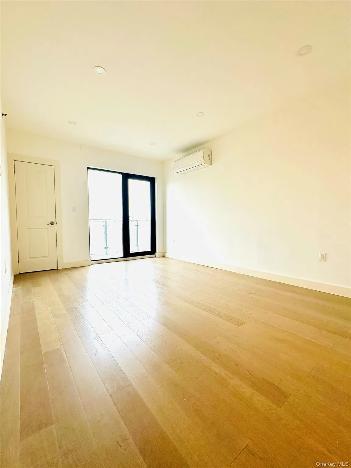 Empty room with recessed lighting, light wood-type flooring, and a wall unit AC Empty room with recessed lighting, light wood-type flooring, and a wall unit AC