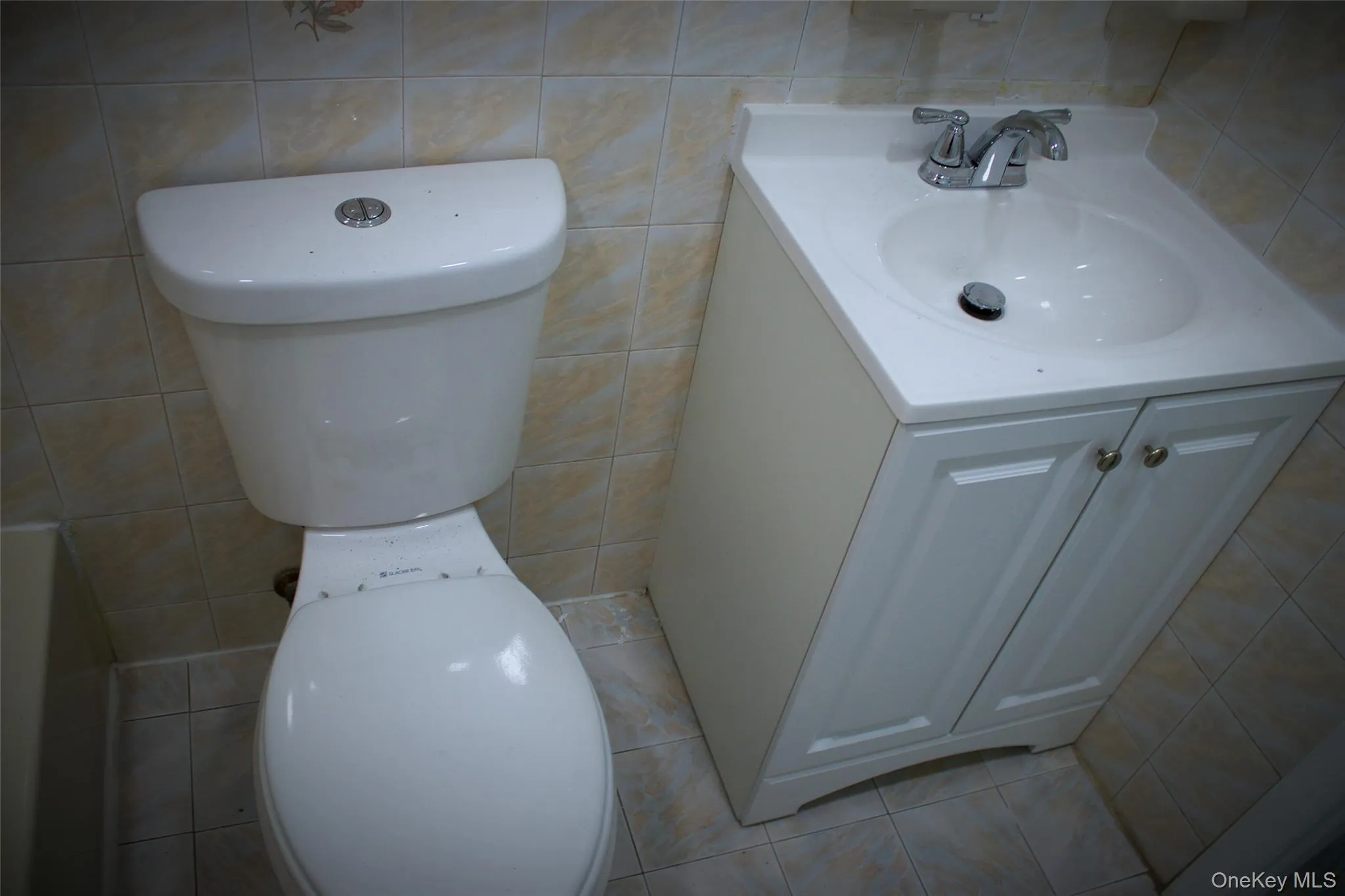 Bathroom featuring tile walls, light tile patterned floors, and vanity Bathroom featuring tile walls, light tile patterned floors, and vanity