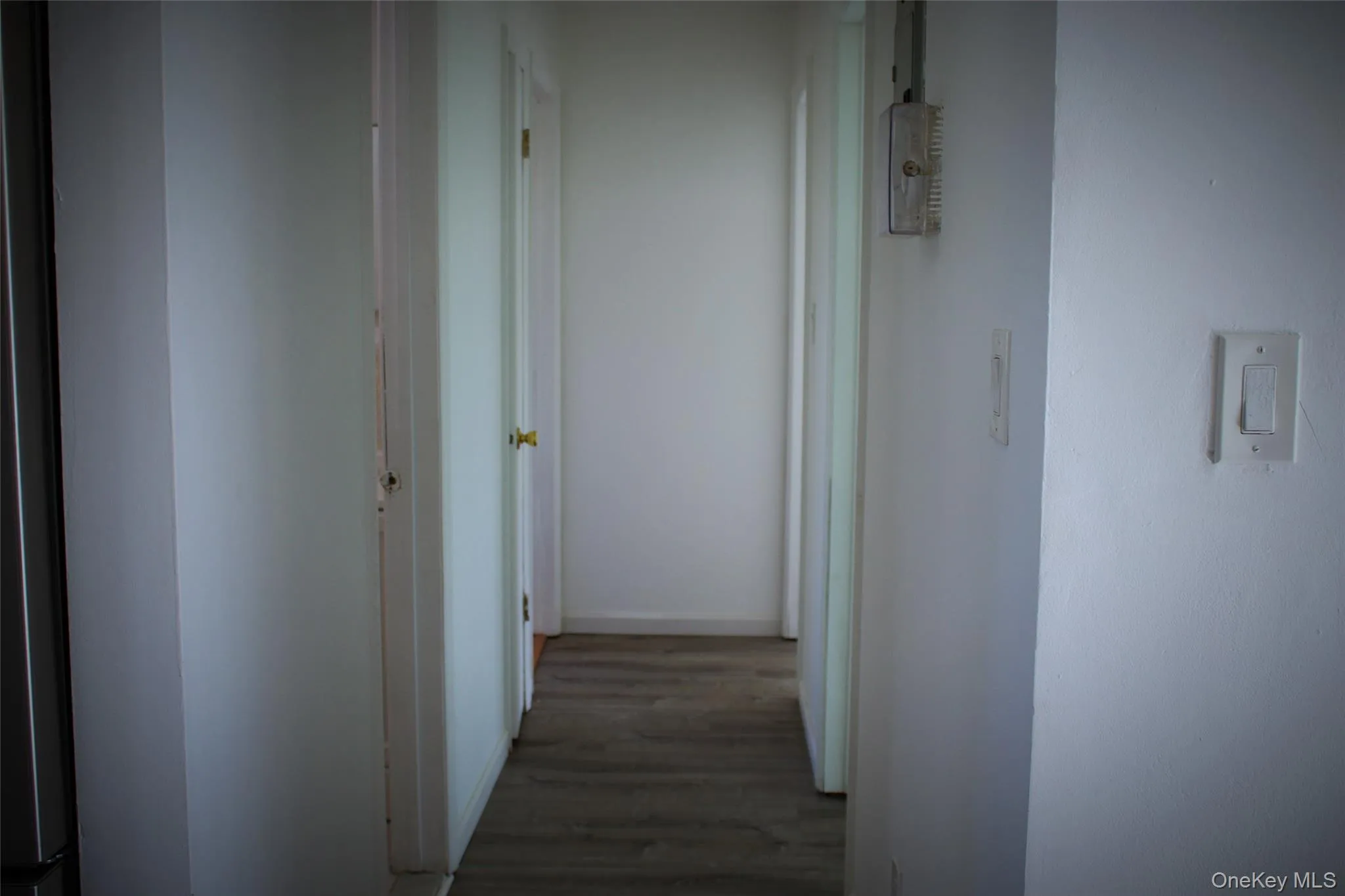 Hallway with wood finished floors and baseboards Hallway with wood finished floors and baseboards