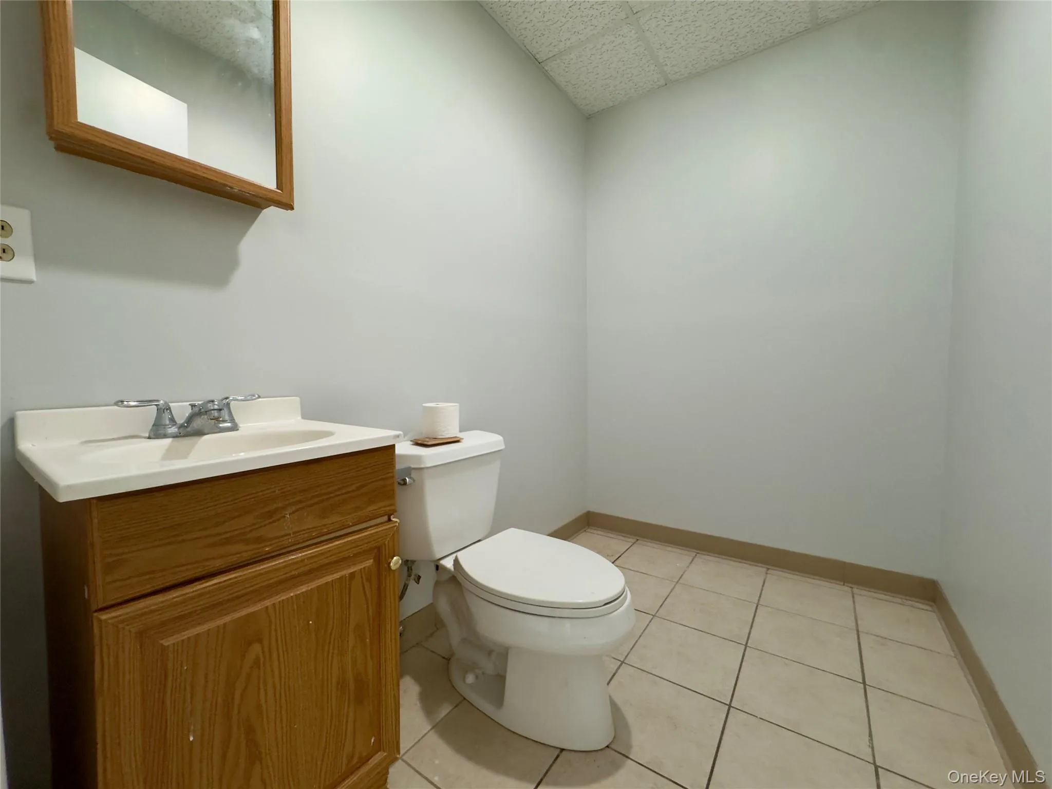 Bathroom with a paneled ceiling, light tile patterned floors, and vanity Bathroom with a paneled ceiling, light tile patterned floors, and vanity