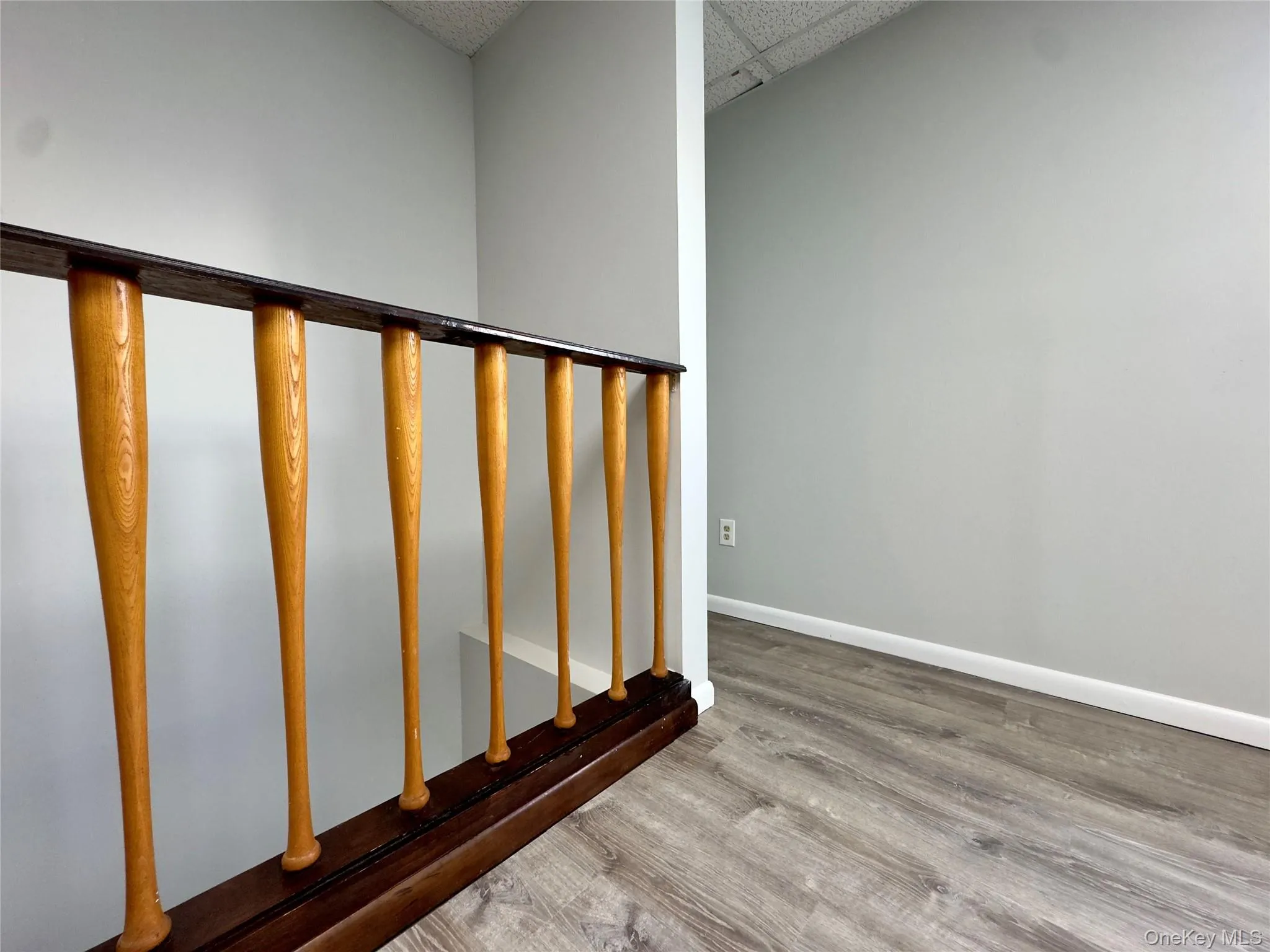 Stairway with light wood-style floors and a paneled ceiling Stairway with light wood-style floors and a paneled ceiling