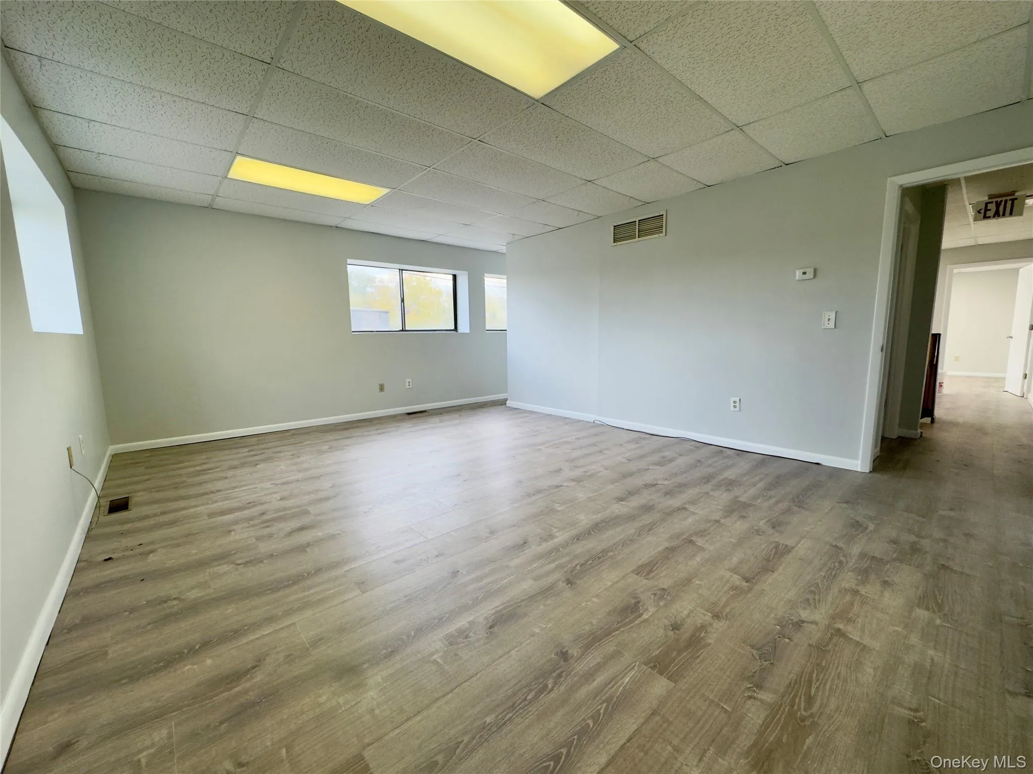 Unfurnished room featuring a paneled ceiling and light wood-style floors Unfurnished room featuring a paneled ceiling and light wood-style floors