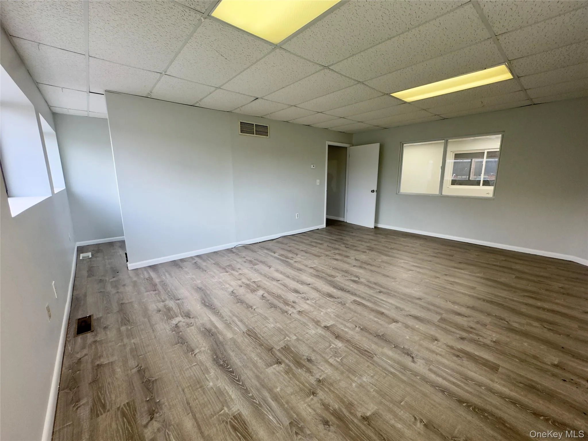Room featuring light wood-style floors and a paneled ceiling Room featuring light wood-style floors and a paneled ceiling
