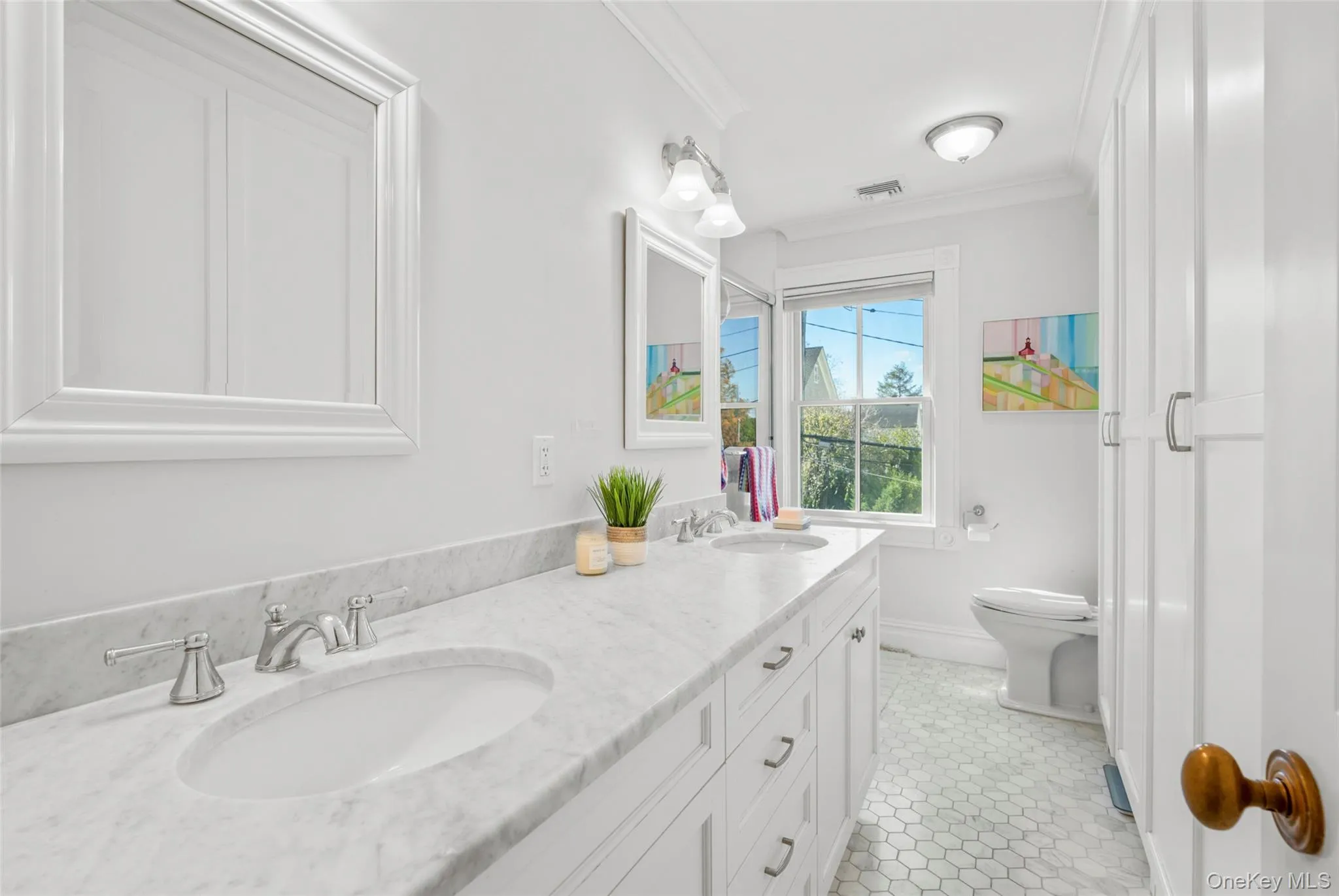 Bathroom featuring crown molding, double vanity, and custom tile patterned flooring with custom built-ins on the right. Bathroom featuring crown molding, double vanity, and custom tile patterned flooring with custom built-ins on the right.