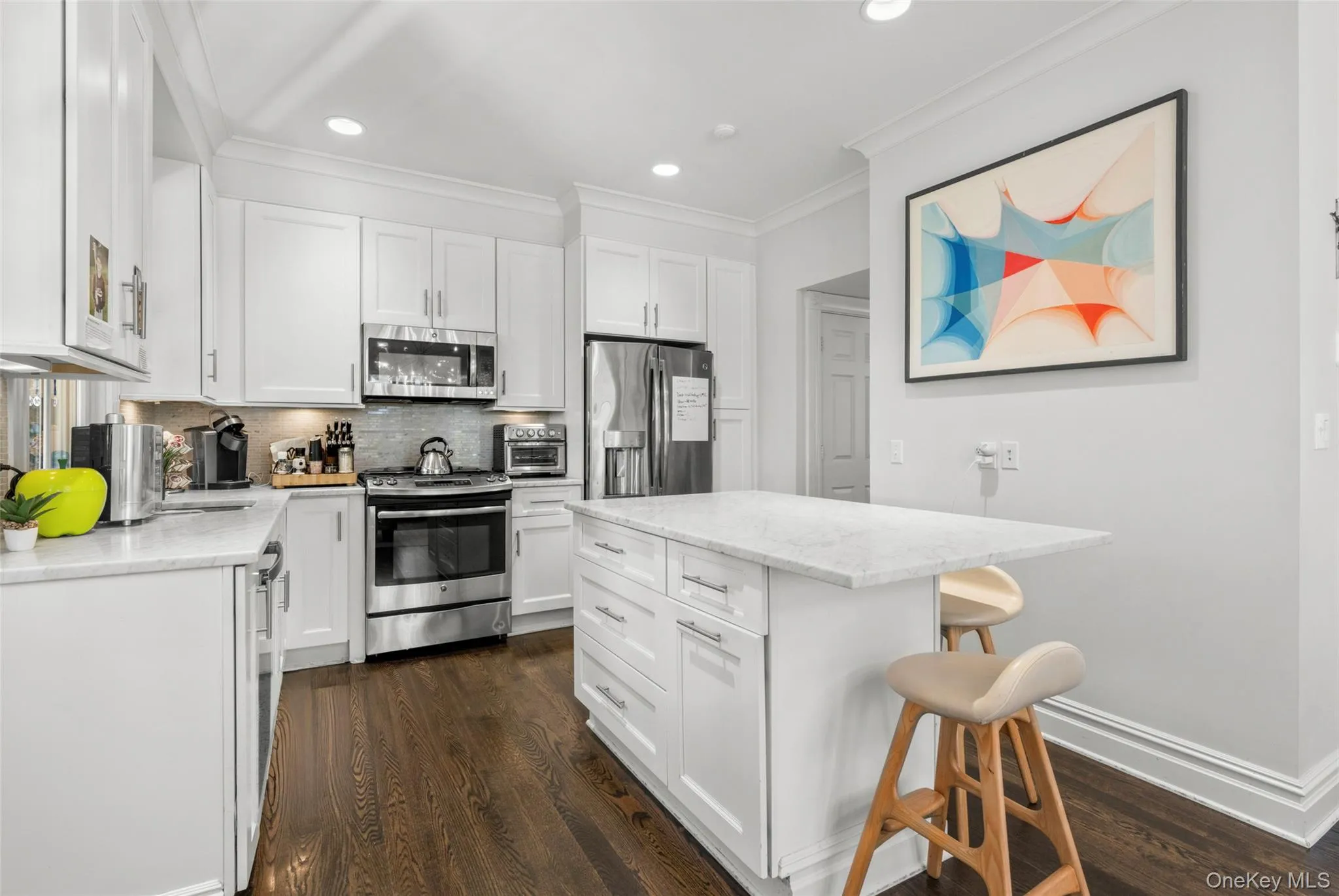 Updated kitchen with quartz counters, a center island, and high-end tile backsplash Updated kitchen with quartz counters, a center island, and high-end tile backsplash
