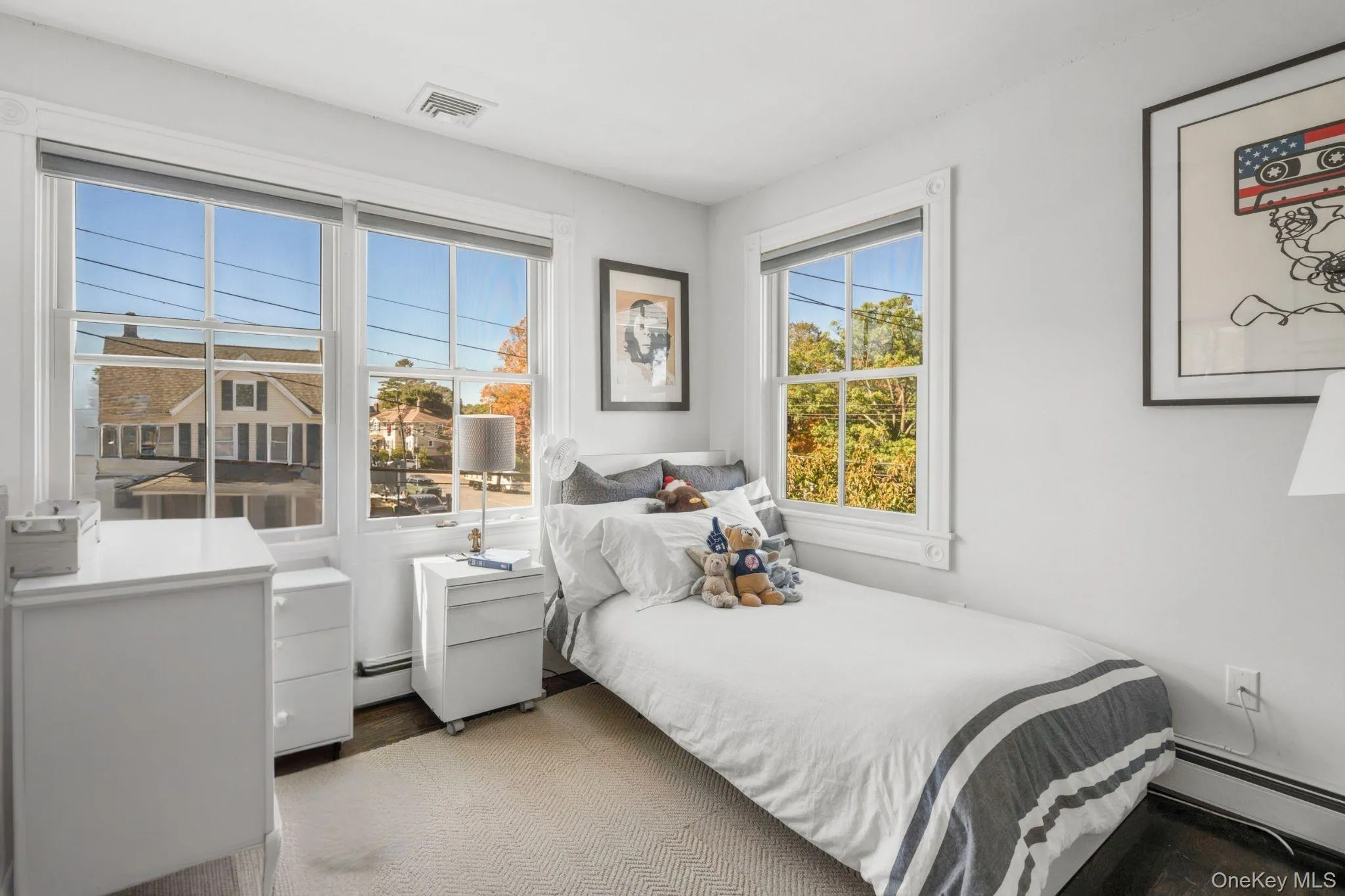 Bedroom with baseboard heating and light wood-style floors. Virtually staged. Bedroom with baseboard heating and light wood-style floors. Virtually staged.