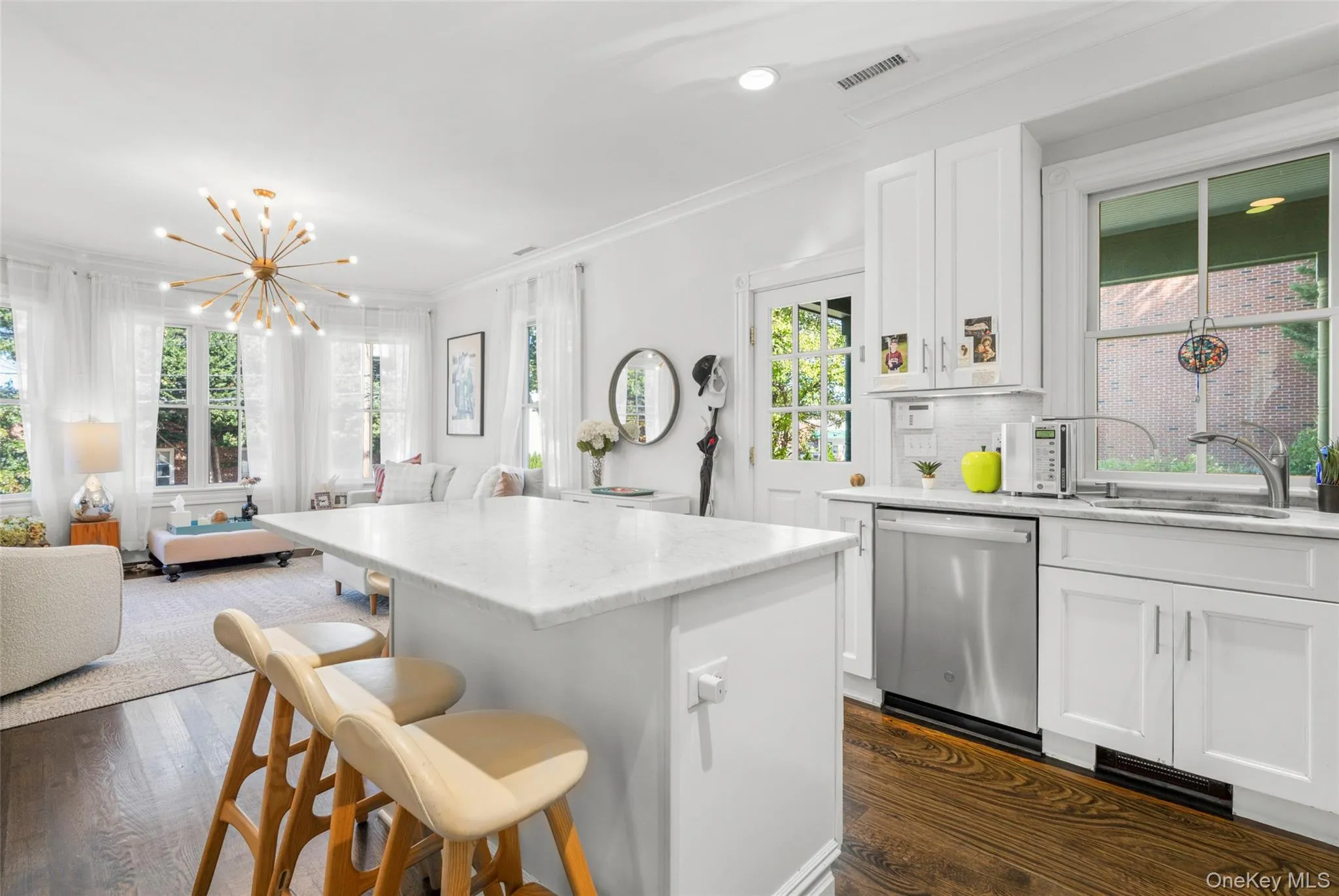 Kitchen with open floor plan, custom cabinetry, classic ornamental molding, a breakfast bar and stainless steel appliances Kitchen with open floor plan, custom cabinetry, classic ornamental molding, a breakfast bar and stainless steel appliances