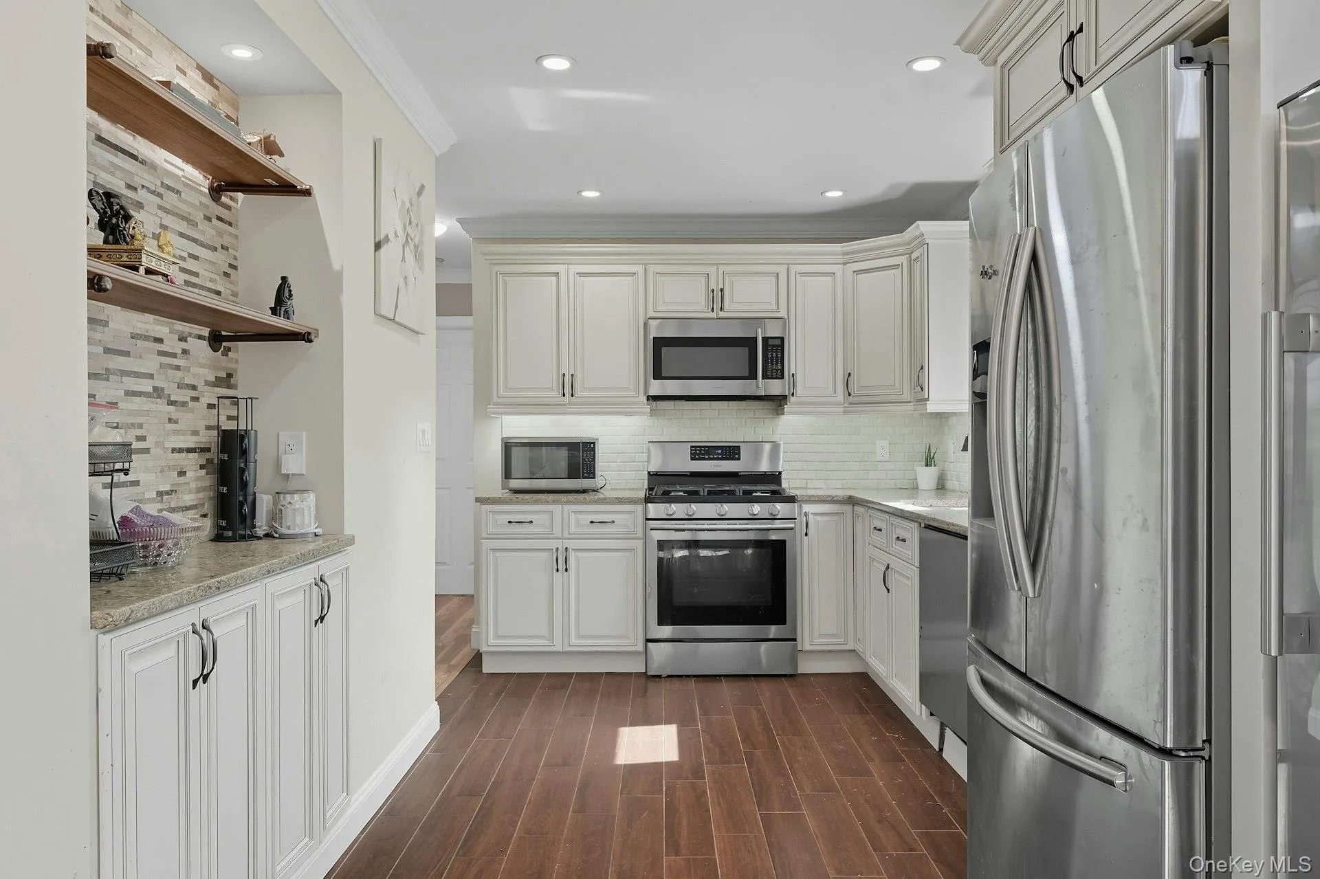 Kitchen featuring built in coffee/tea bar with open shelving above and storage below. Recess lighting. Kitchen featuring built in coffee/tea bar with open shelving above and storage below. Recess lighting.
