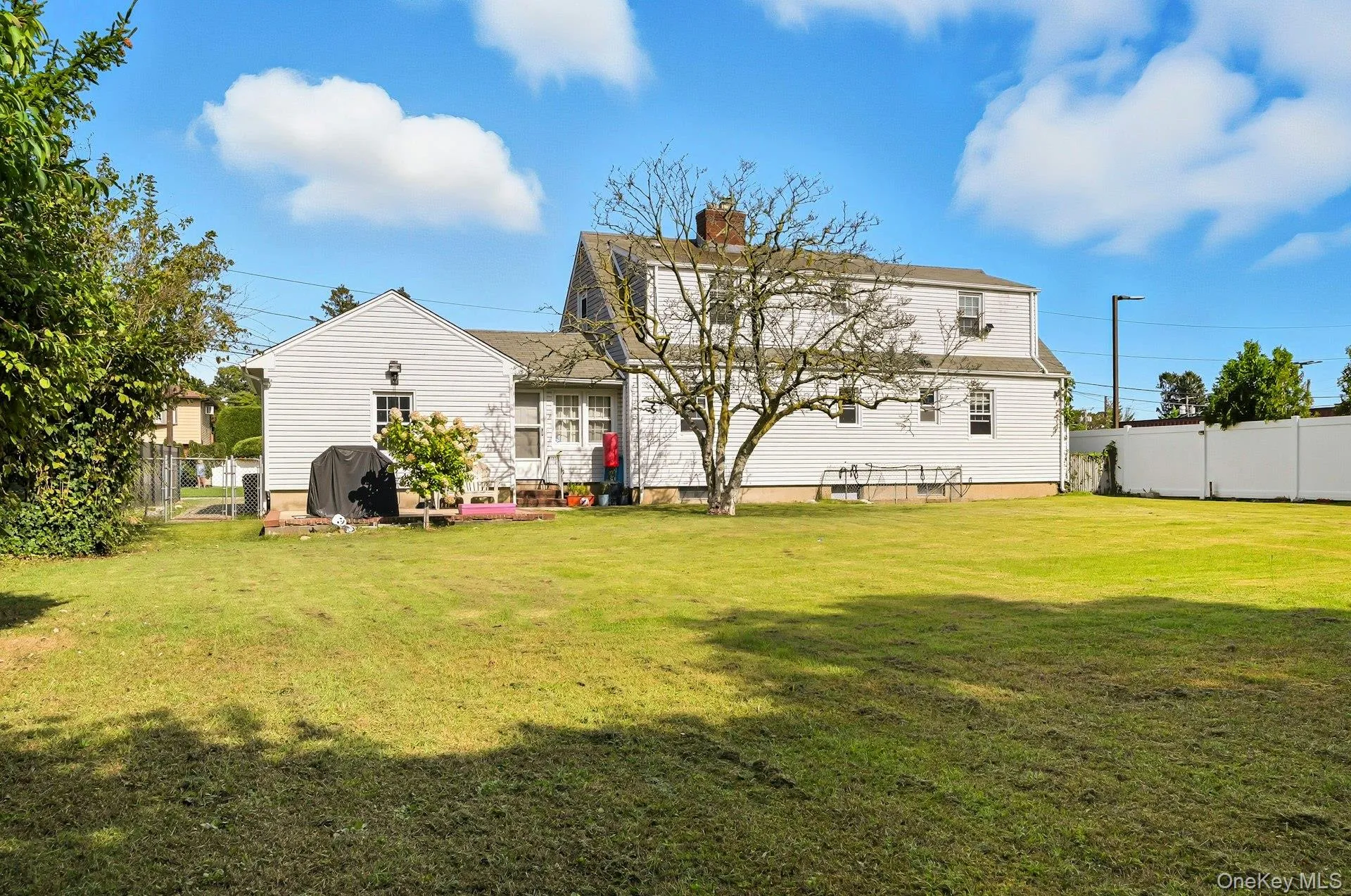 Back of property with a chimney and small patio Back of property with a chimney and small patio