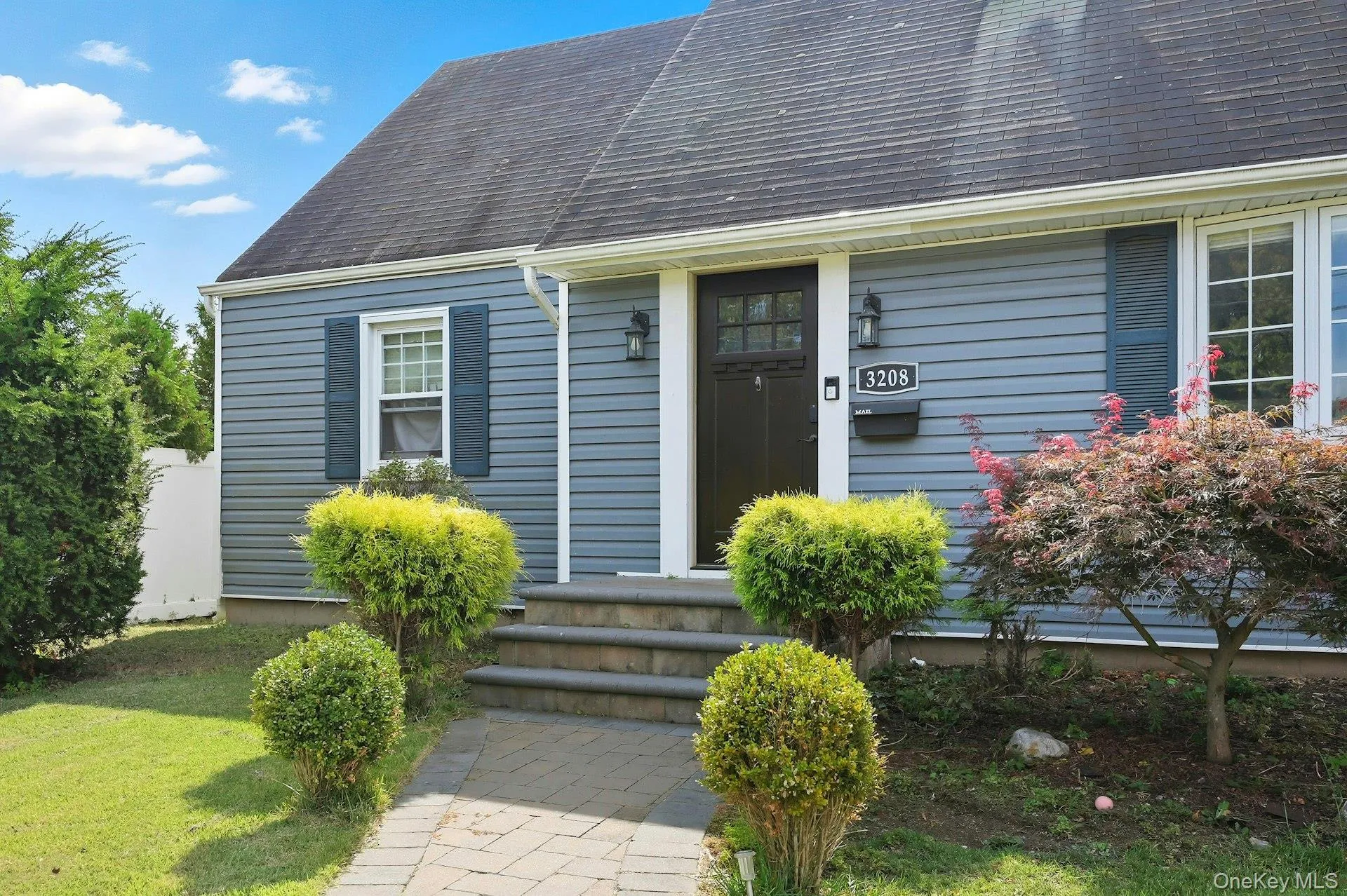 View of exterior entry featuring roof with shingles and a lawn View of exterior entry featuring roof with shingles and a lawn