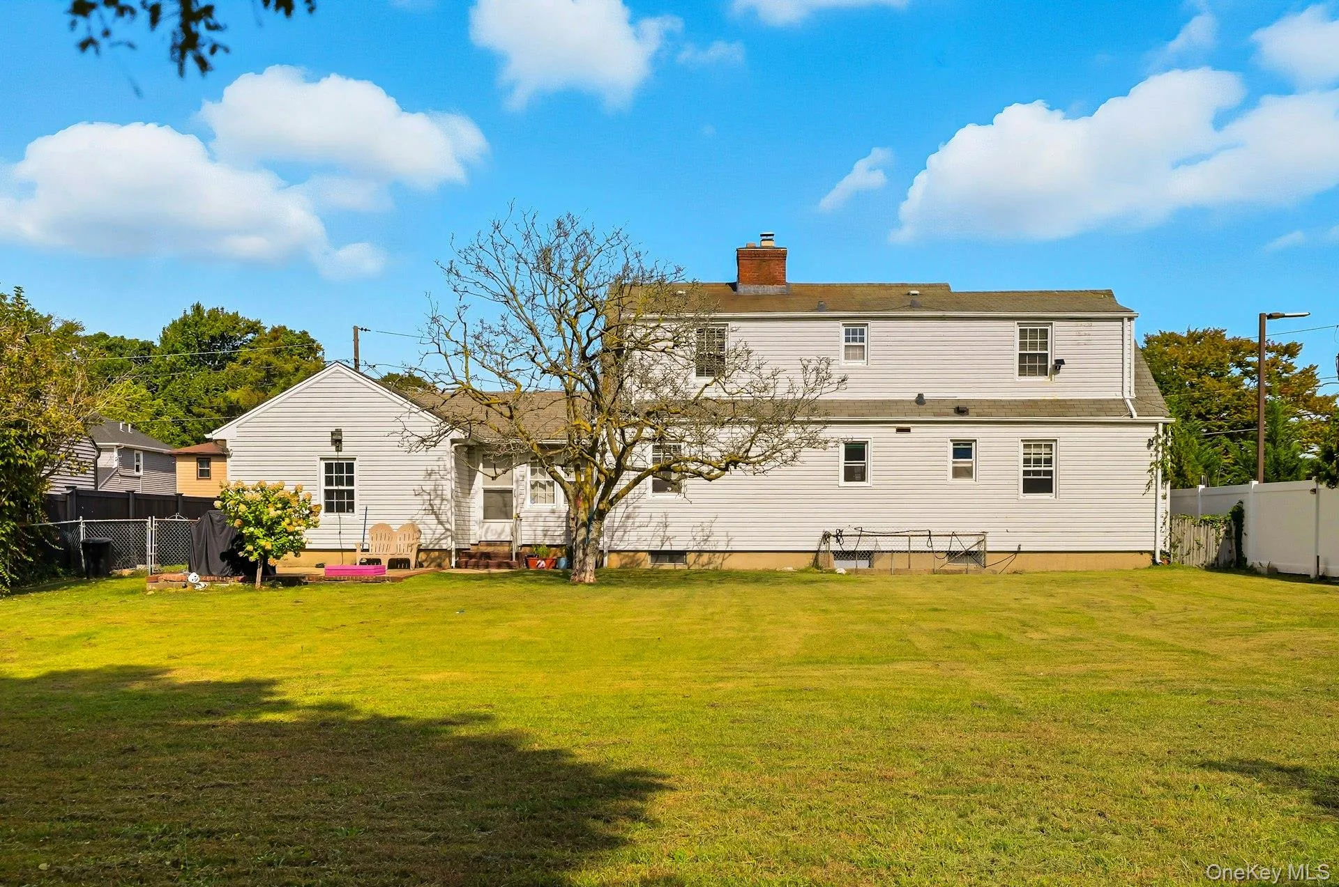 Rear view of property featuring a fenced backyard and a chimney Rear view of property featuring a fenced backyard and a chimney
