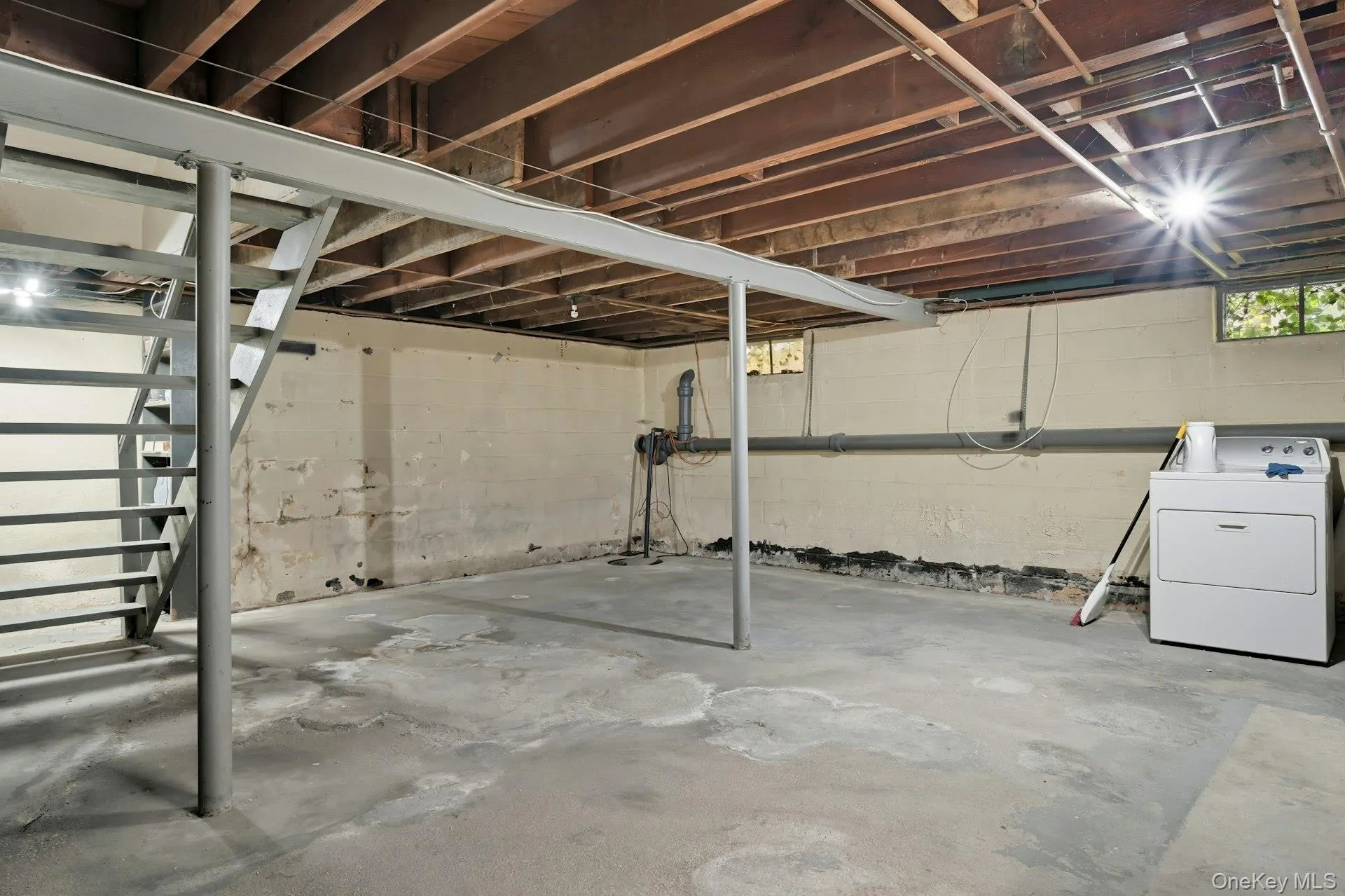 Unfinished Basement featuring clothes dryer & washer, utilities, high ceilings Unfinished Basement featuring clothes dryer & washer, utilities, high ceilings