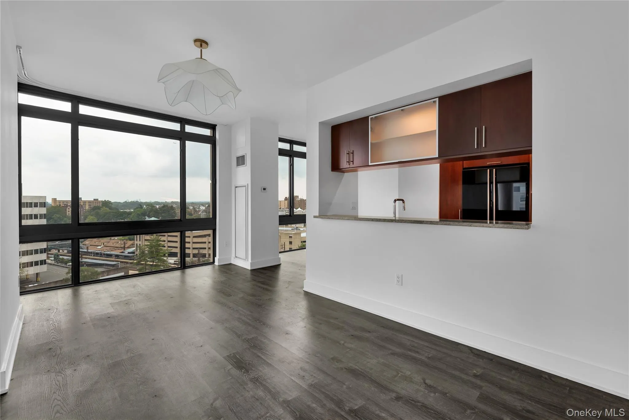 Unfurnished living room featuring a wall of windows and kitchen Unfurnished living room featuring a wall of windows and kitchen