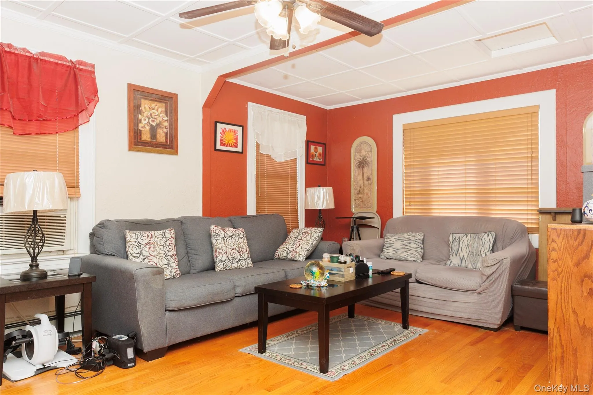 Living room with wood finished floors, ceiling fan, and cooling unit Living room with wood finished floors, ceiling fan, and cooling unit
