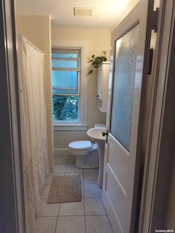 Full bathroom with light tile patterned floors and toilet Full bathroom with light tile patterned floors and toilet