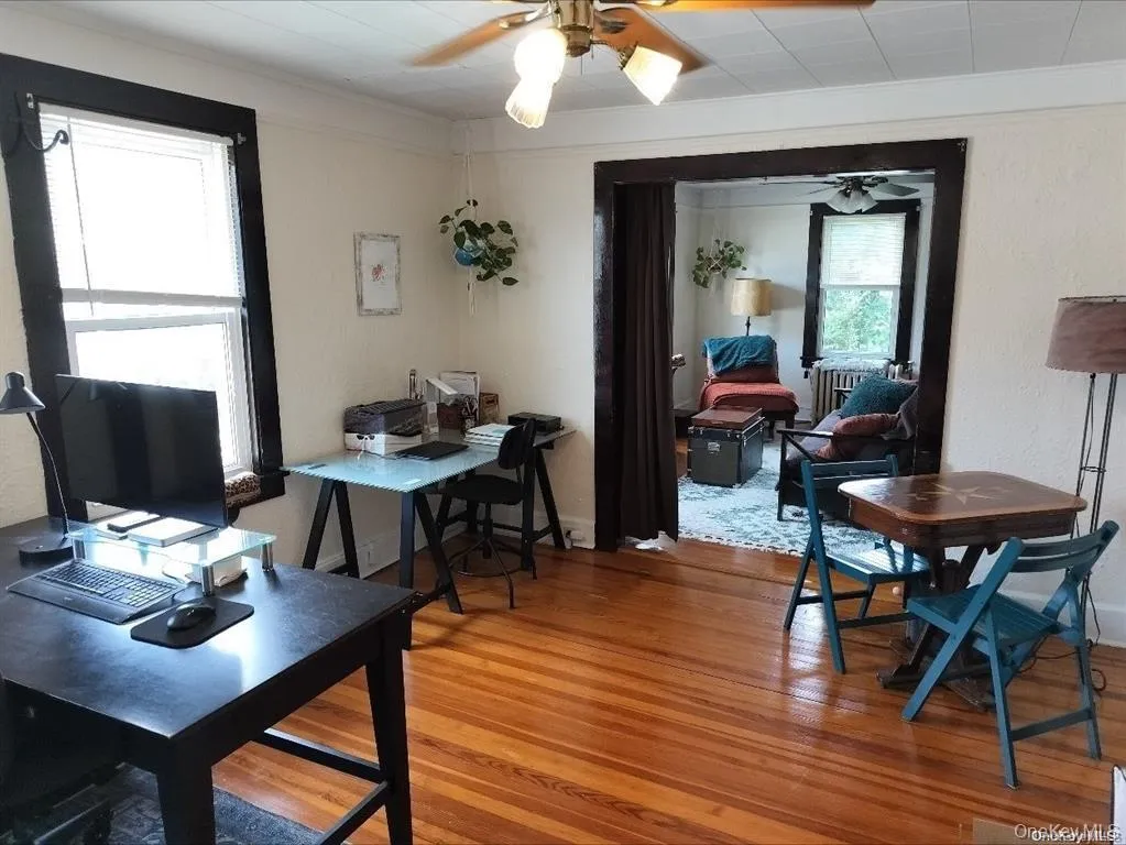 Dining area featuring light wood-style floors, a desk, ceiling fan, and ornamental molding Dining area featuring light wood-style floors, a desk, ceiling fan, and ornamental molding