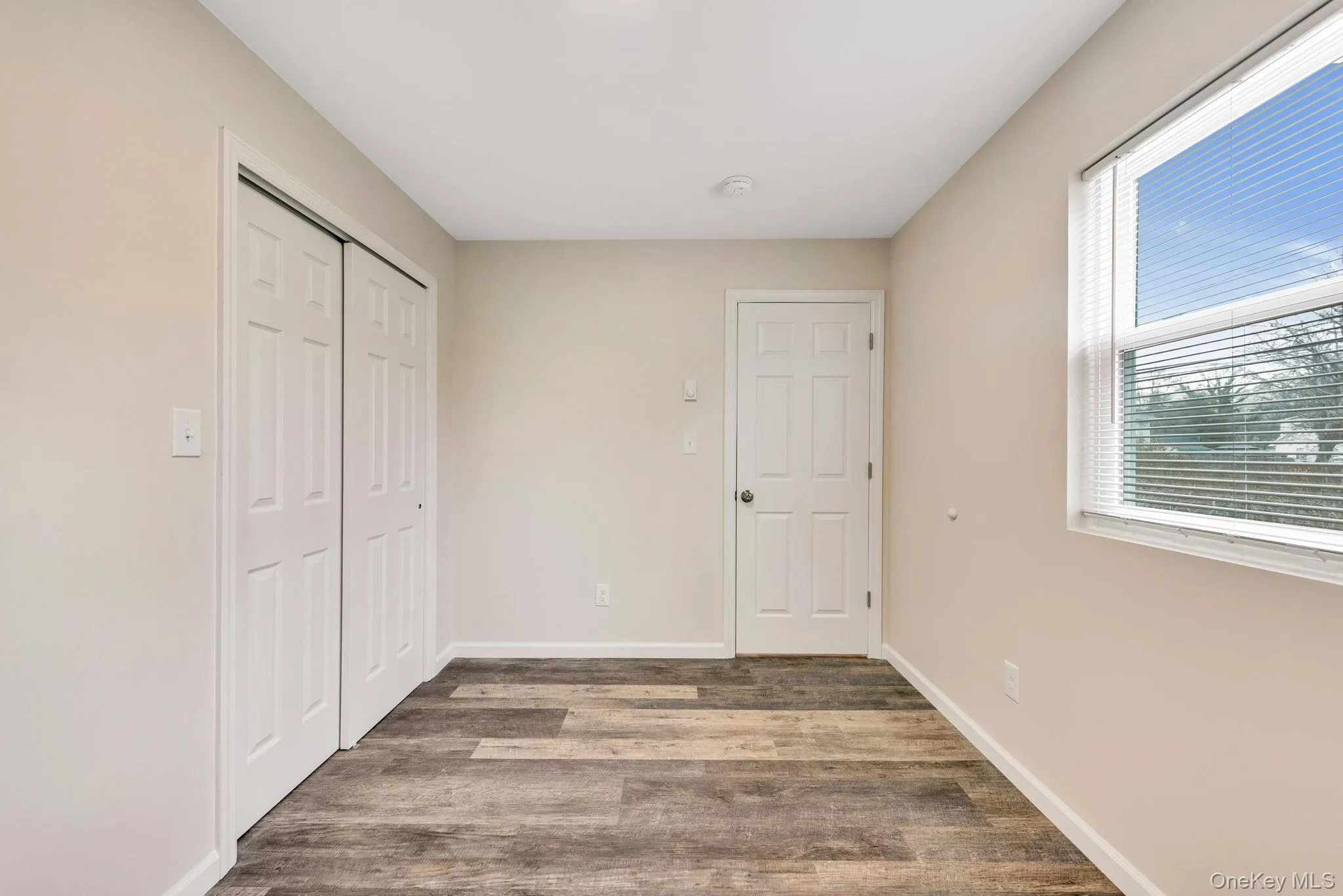 Unfurnished bedroom with a closet and wood finished floors Unfurnished bedroom with a closet and wood finished floors