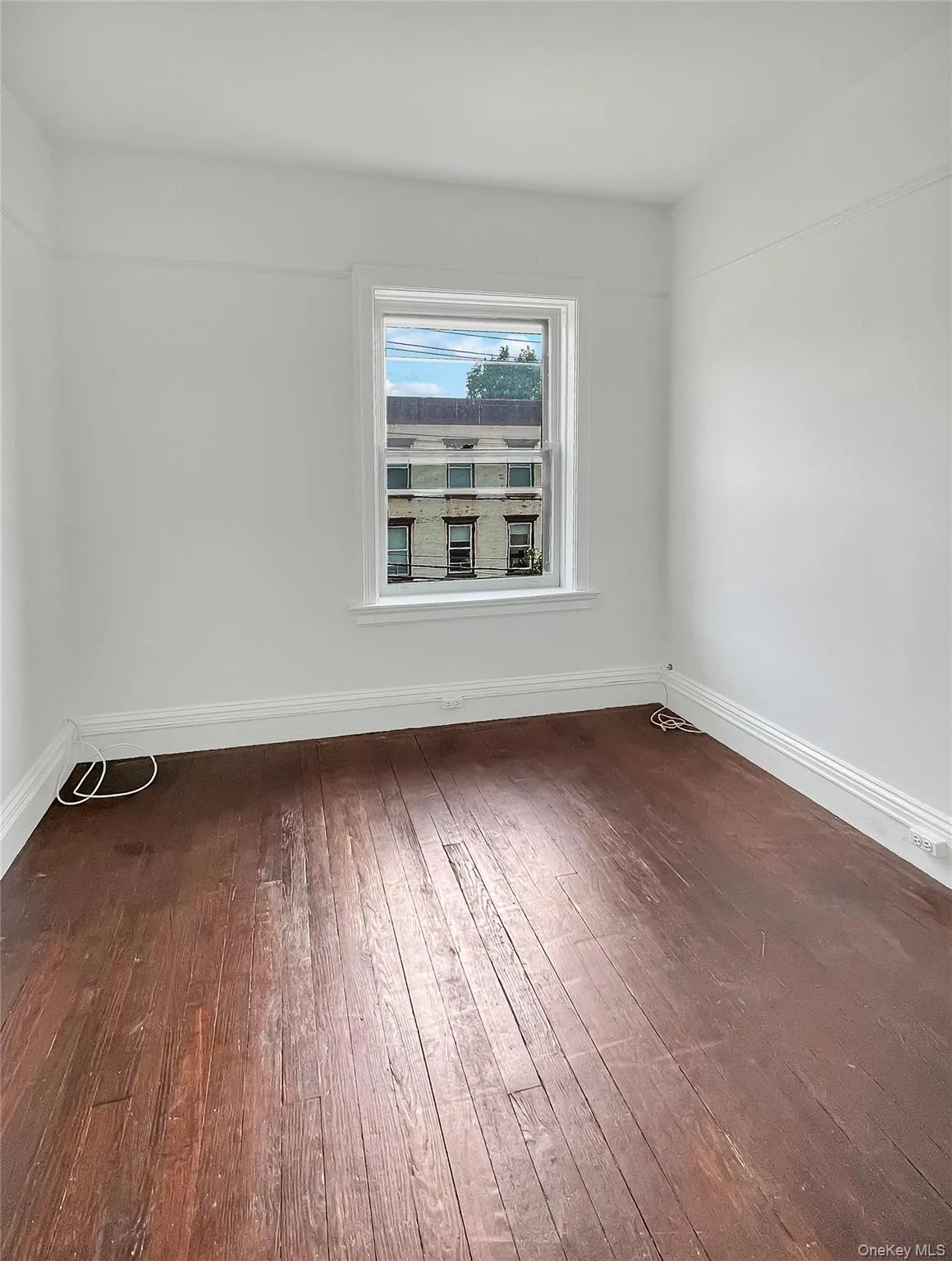 Empty room with baseboards and dark wood finished floors Empty room with baseboards and dark wood finished floors