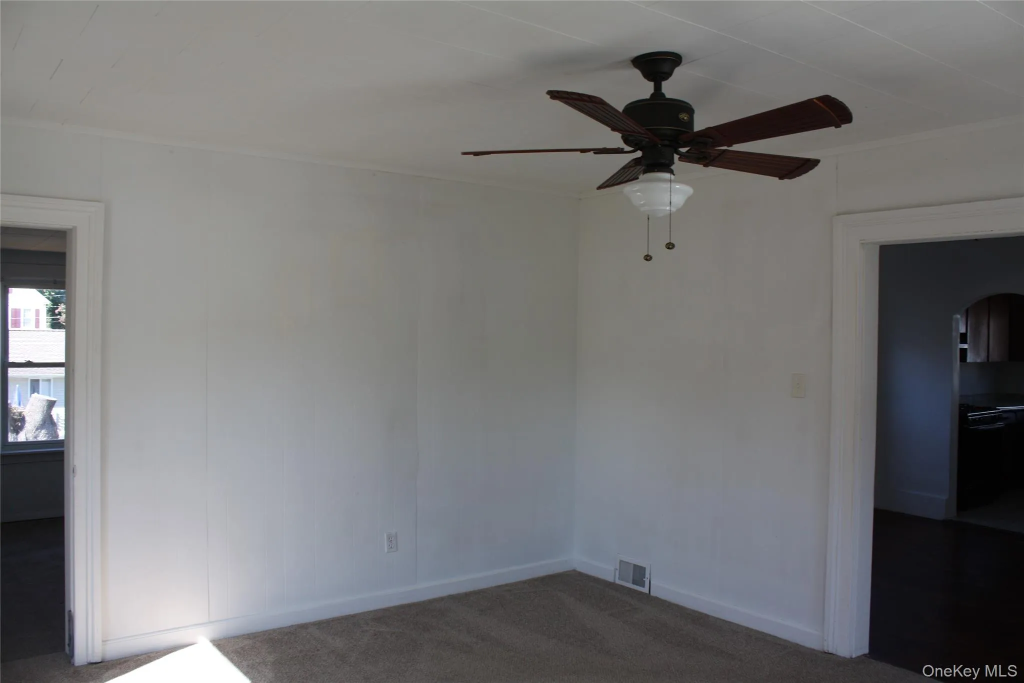 Unfurnished room featuring carpet, a ceiling fan, and ornamental molding Unfurnished room featuring carpet, a ceiling fan, and ornamental molding
