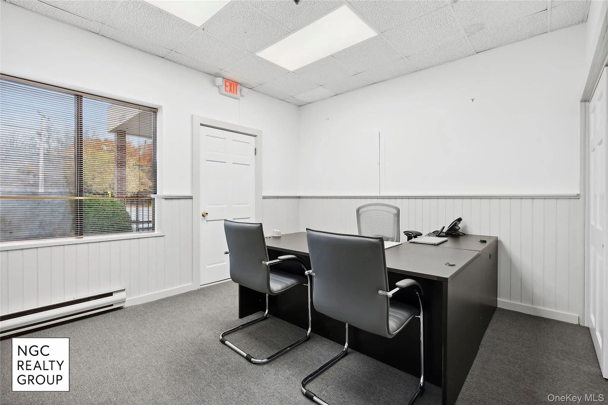 Home office featuring a baseboard heating unit, wainscoting, and a drop ceiling Home office featuring a baseboard heating unit, wainscoting, and a drop ceiling