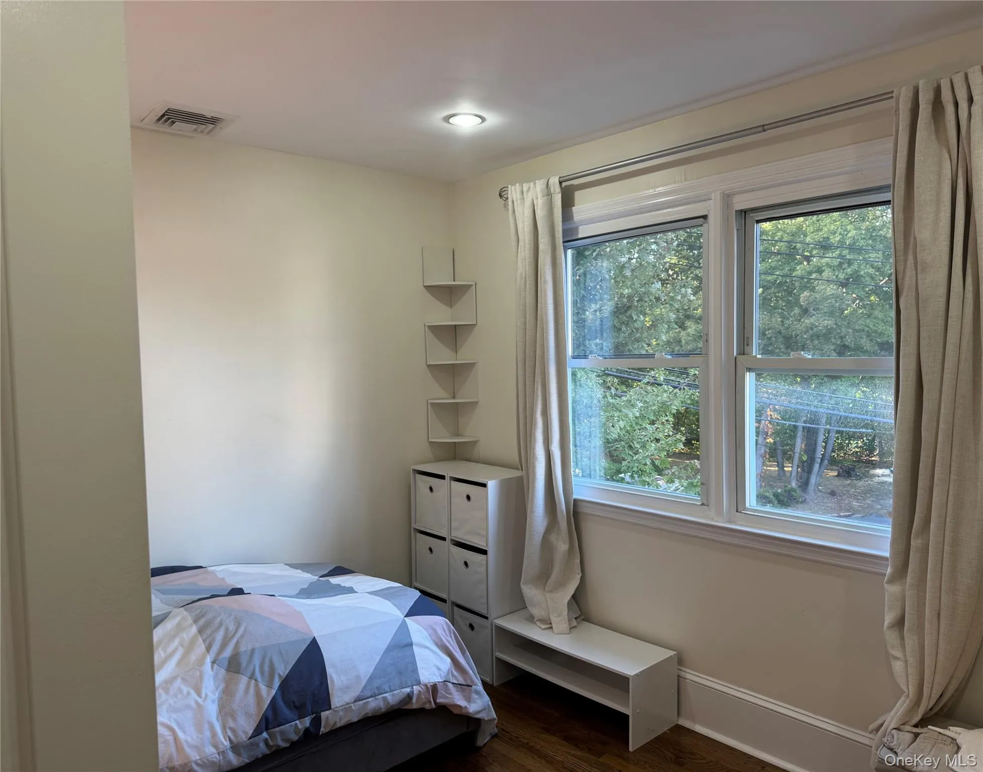 Bedroom featuring dark wood finished floors and baseboards Bedroom featuring dark wood finished floors and baseboards
