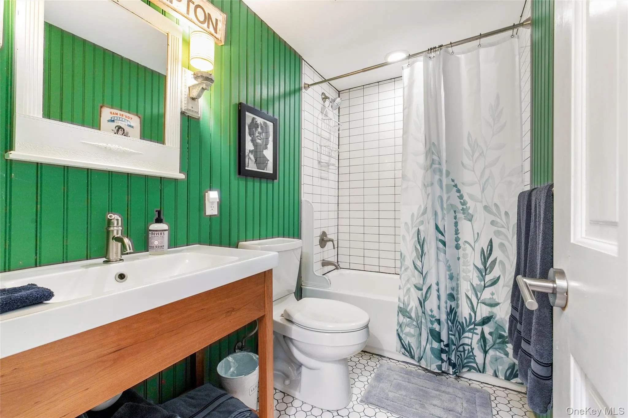 Full bathroom with shower / tub combo, vanity, and light tile patterned floors Full bathroom with shower / tub combo, vanity, and light tile patterned floors