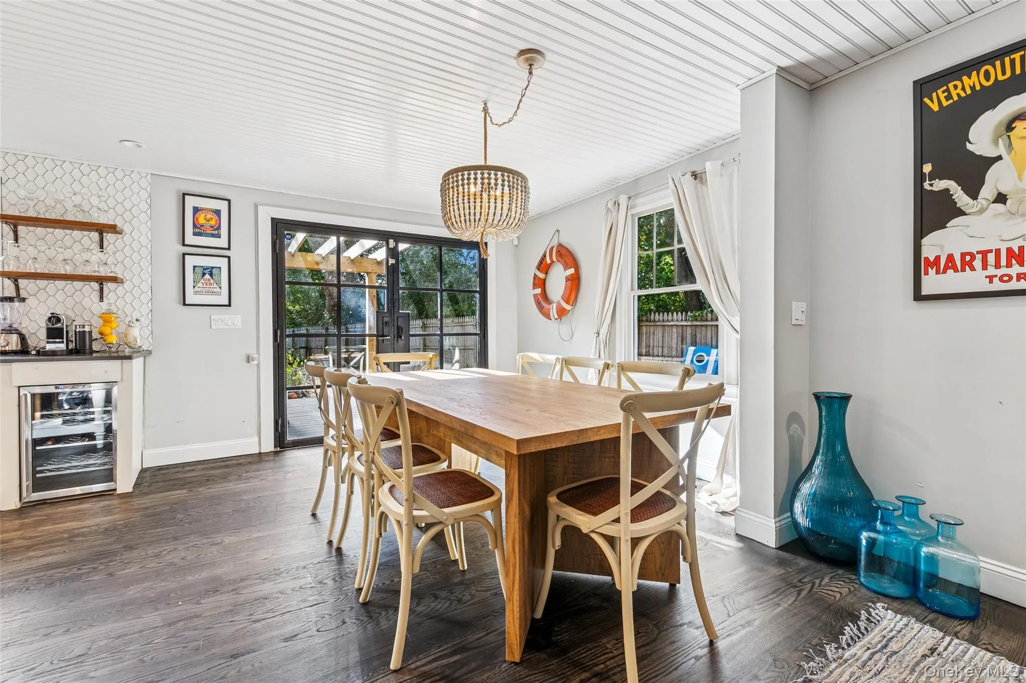 Dining room with beverage cooler, dark wood-style flooring, and a chandelier Dining room with beverage cooler, dark wood-style flooring, and a chandelier