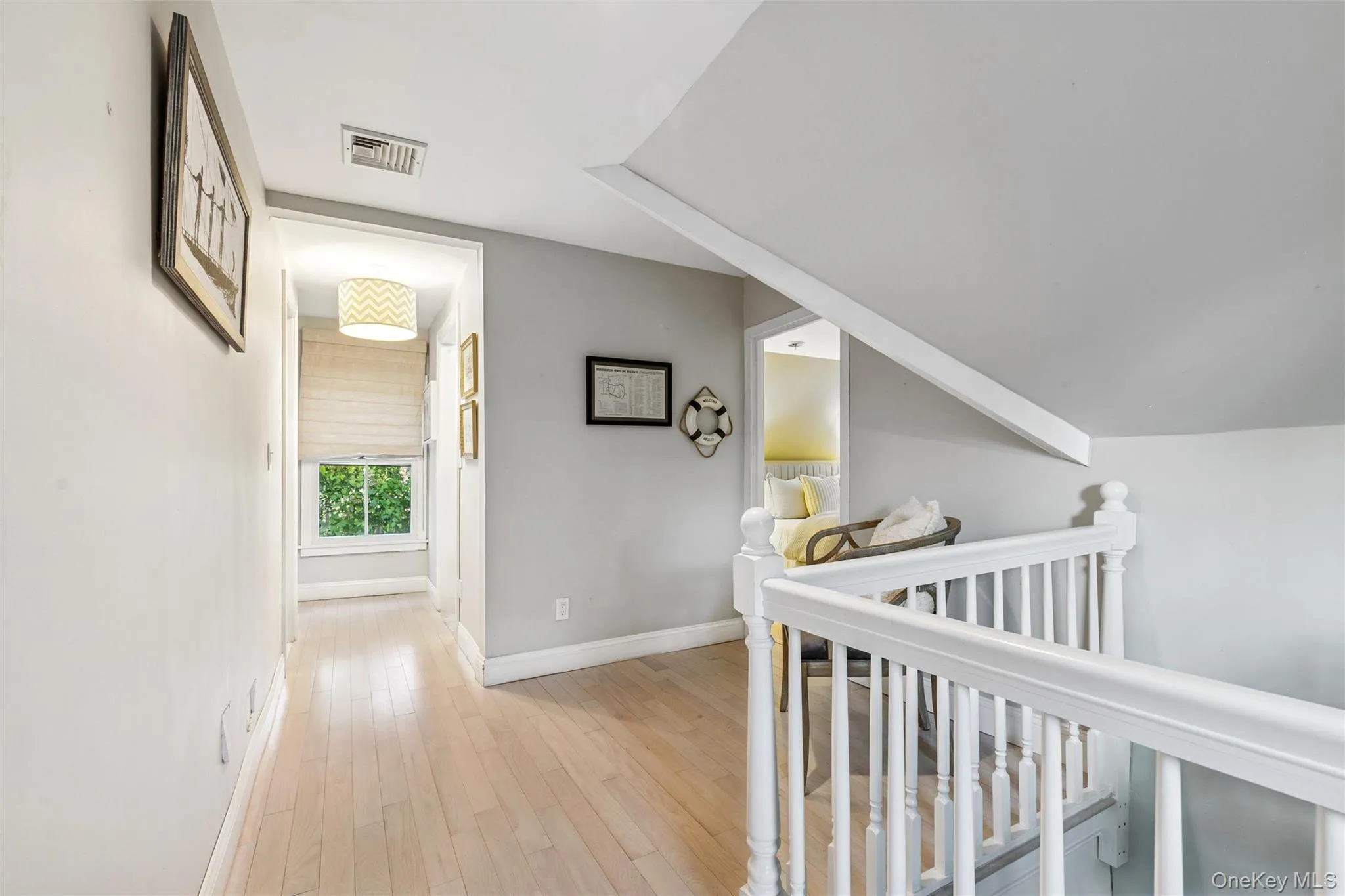 Corridor with light wood-style flooring and an upstairs landing Corridor with light wood-style flooring and an upstairs landing