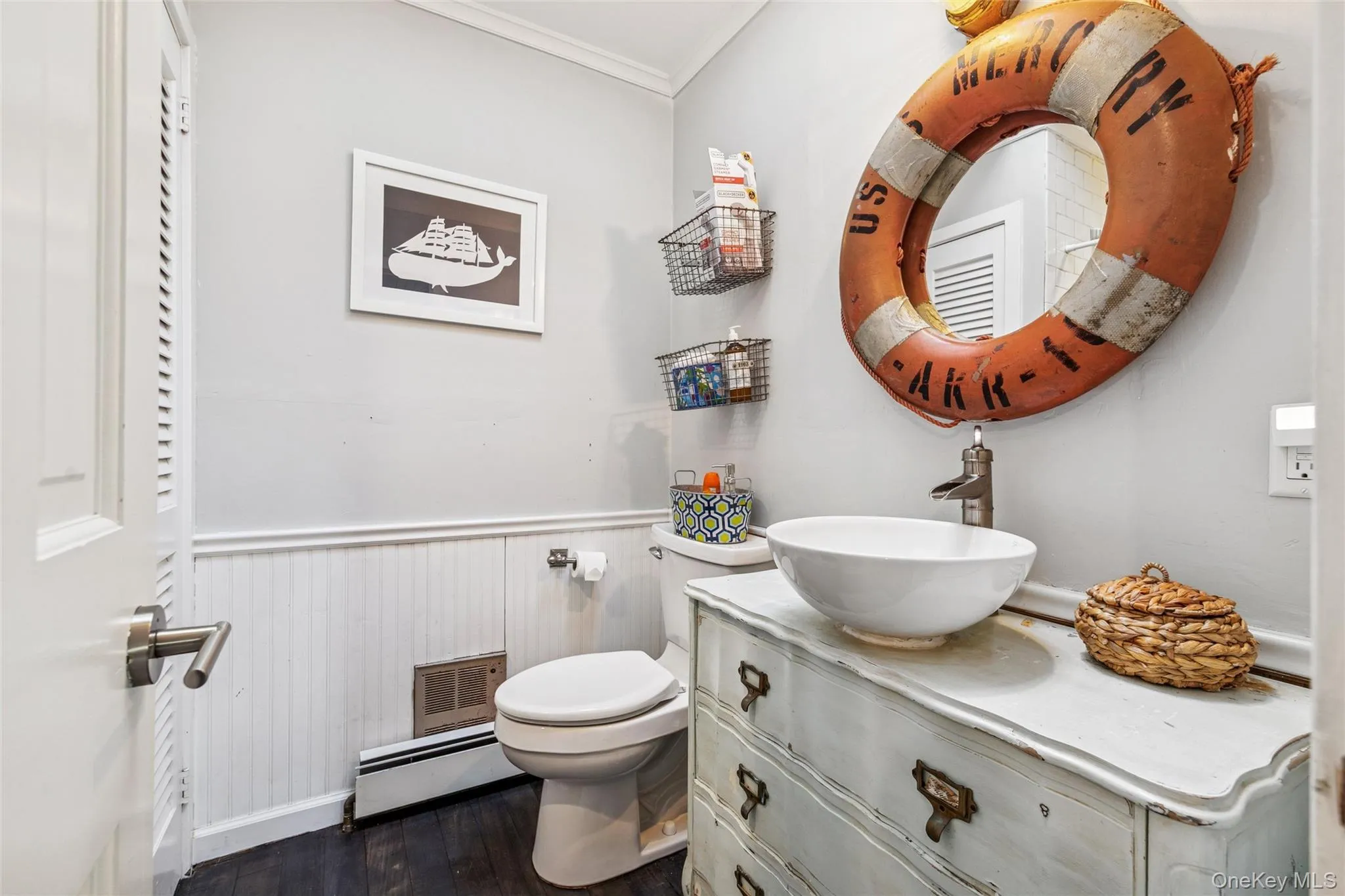 Bathroom with dark wood-type flooring, vanity, a wainscoted wall, a baseboard heating unit, and ornamental molding Bathroom with dark wood-type flooring, vanity, a wainscoted wall, a baseboard heating unit, and ornamental molding