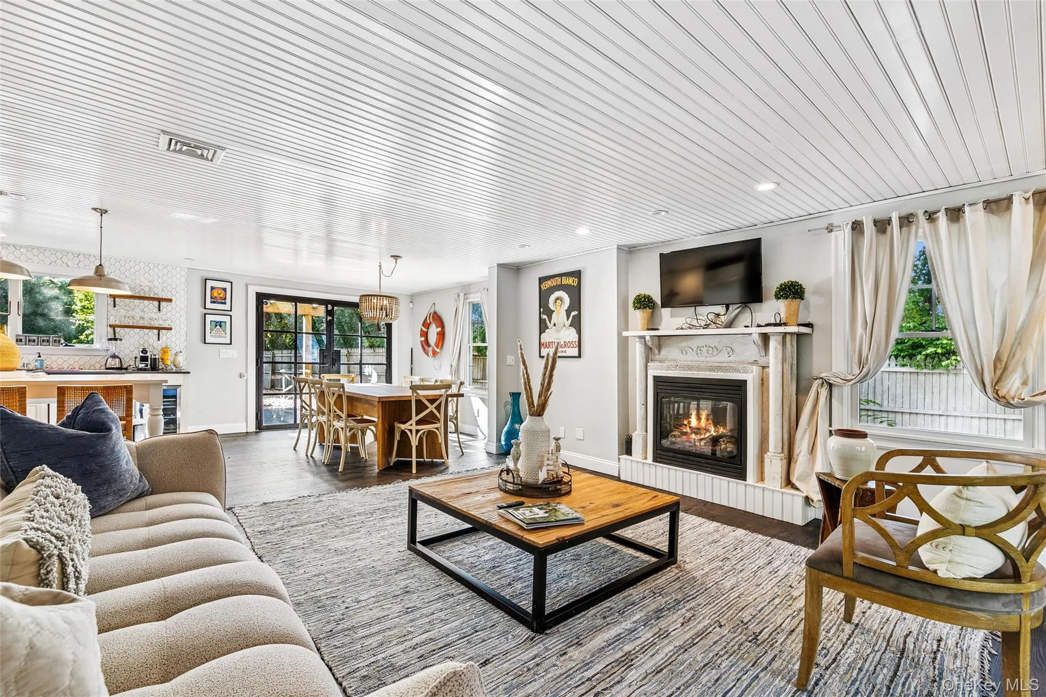 Living area with a glass covered fireplace, wood finished floors, and wooden ceiling Living area with a glass covered fireplace, wood finished floors, and wooden ceiling