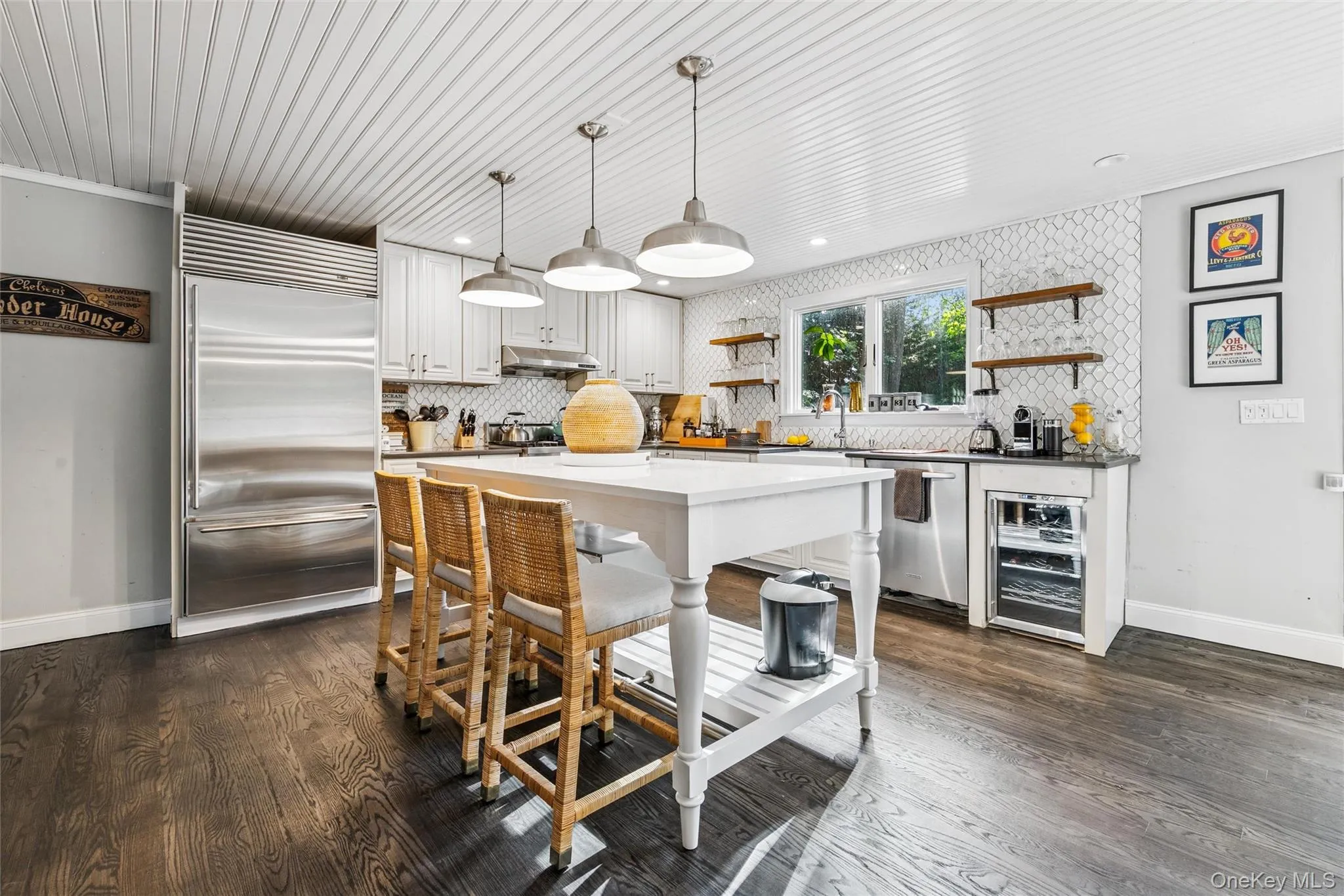 Kitchen with open shelves, hanging light fixtures, appliances with stainless steel finishes, and decorative backsplash Kitchen with open shelves, hanging light fixtures, appliances with stainless steel finishes, and decorative backsplash