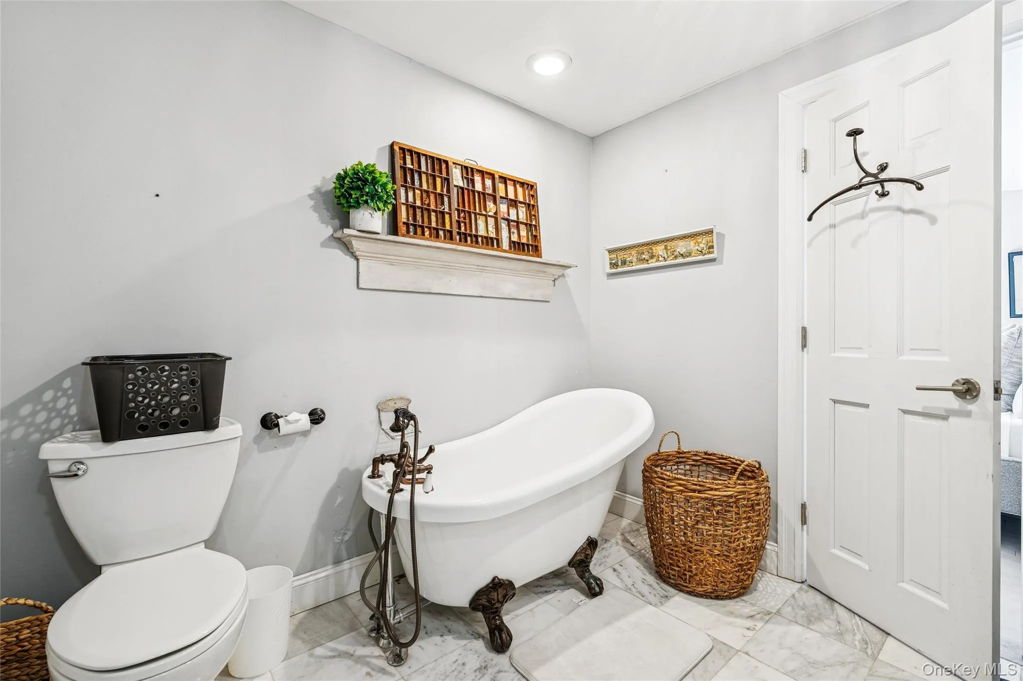 Full bath featuring a freestanding bath and marble look tiles Full bath featuring a freestanding bath and marble look tiles