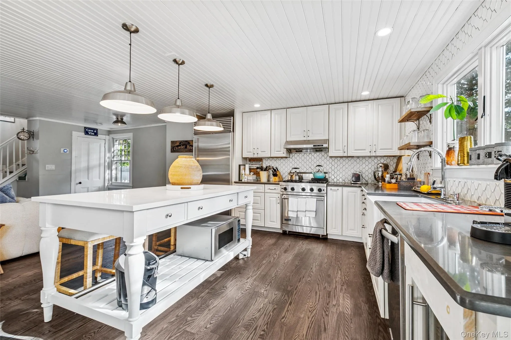 Kitchen with open shelves, backsplash, dark wood-style floors, pendant lighting, and white cabinets Kitchen with open shelves, backsplash, dark wood-style floors, pendant lighting, and white cabinets