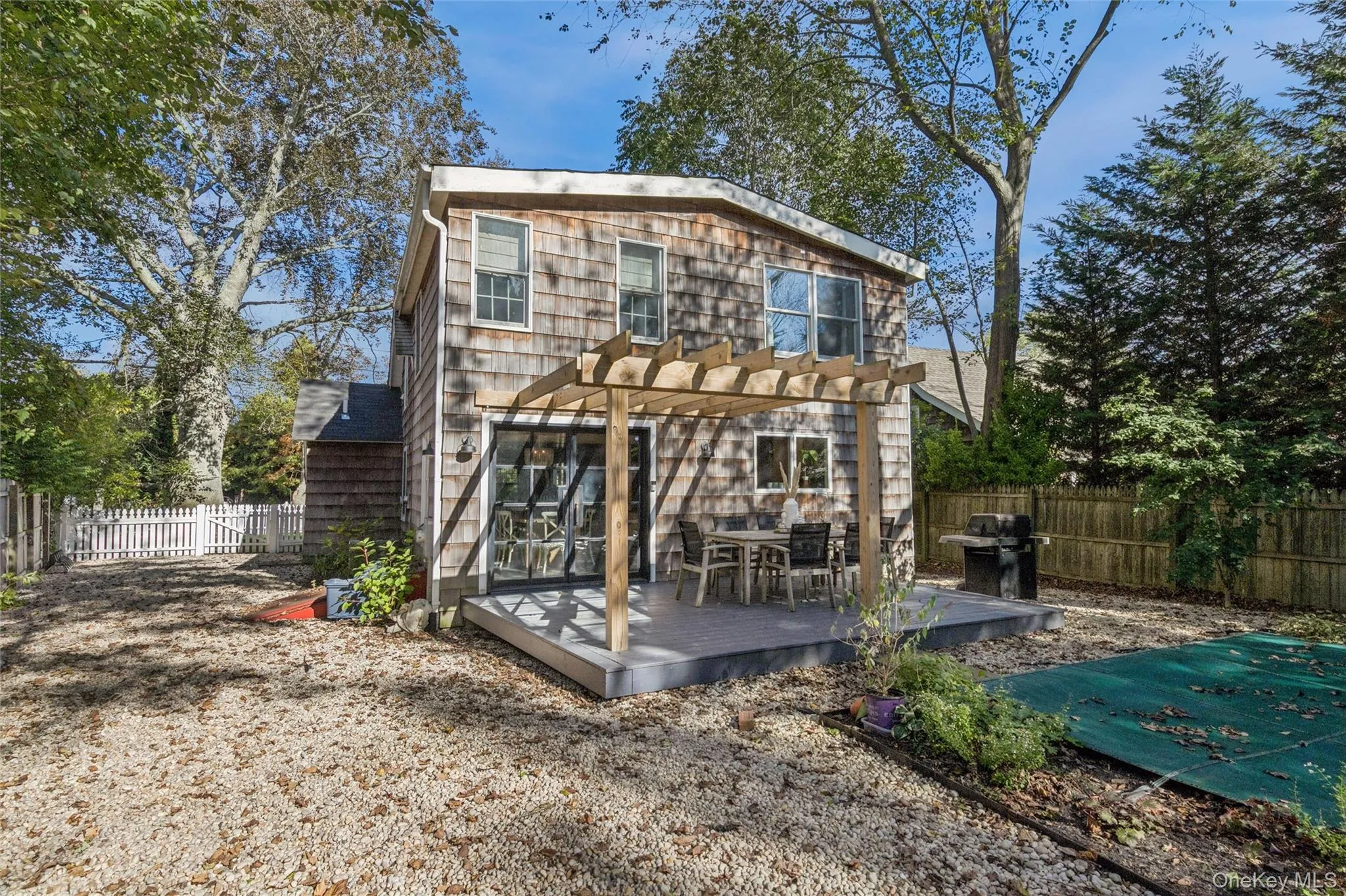 Back of property with a fenced backyard, a wooden deck, and a pergola Back of property with a fenced backyard, a wooden deck, and a pergola