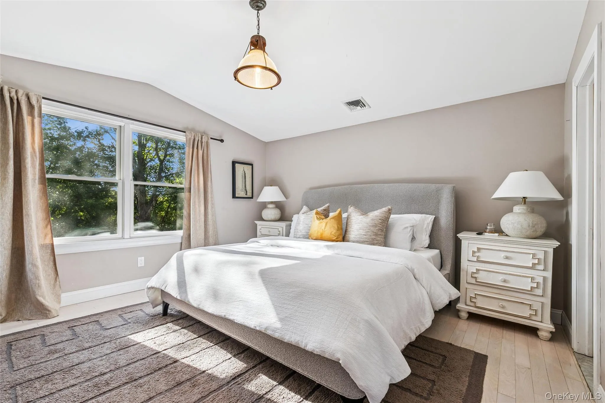 Bedroom with lofted ceiling and light wood-style flooring Bedroom with lofted ceiling and light wood-style flooring