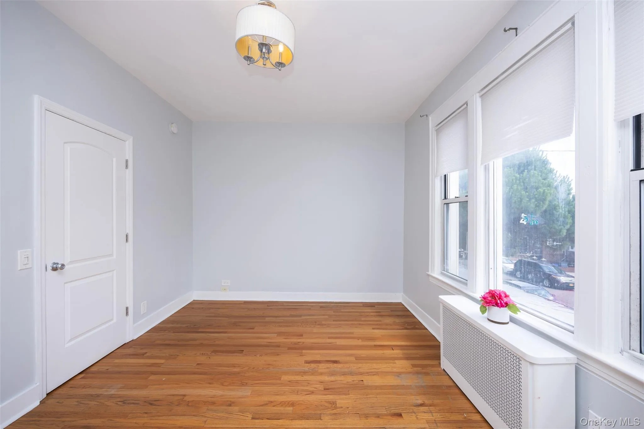 Empty room with radiator heating unit and light wood-style flooring Empty room with radiator heating unit and light wood-style flooring