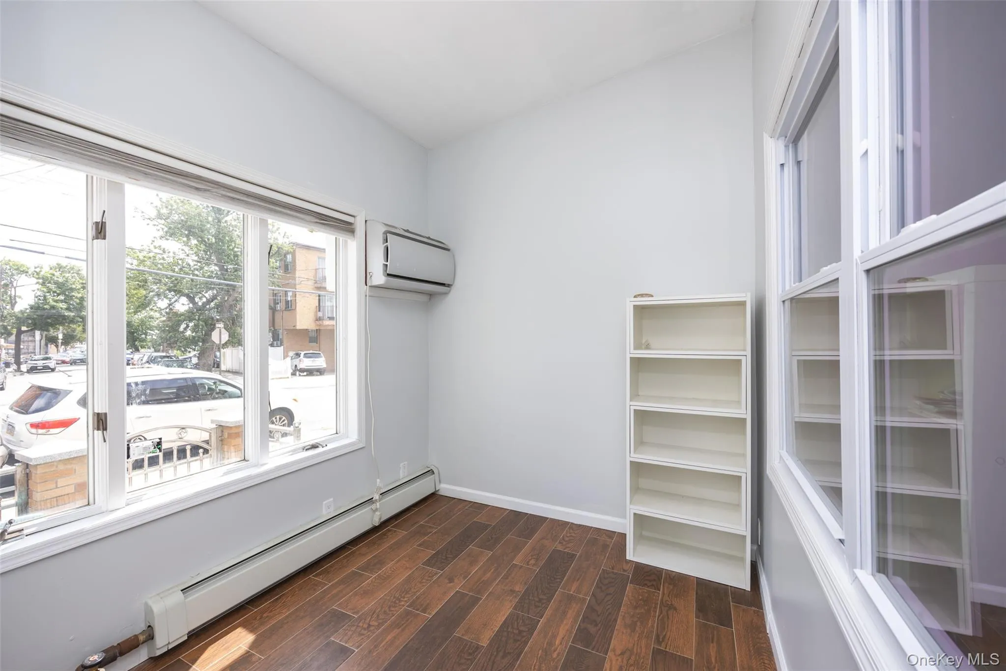 Spacious closet with a baseboard radiator, wood tiled floors, and a wall mounted air conditioner Spacious closet with a baseboard radiator, wood tiled floors, and a wall mounted air conditioner