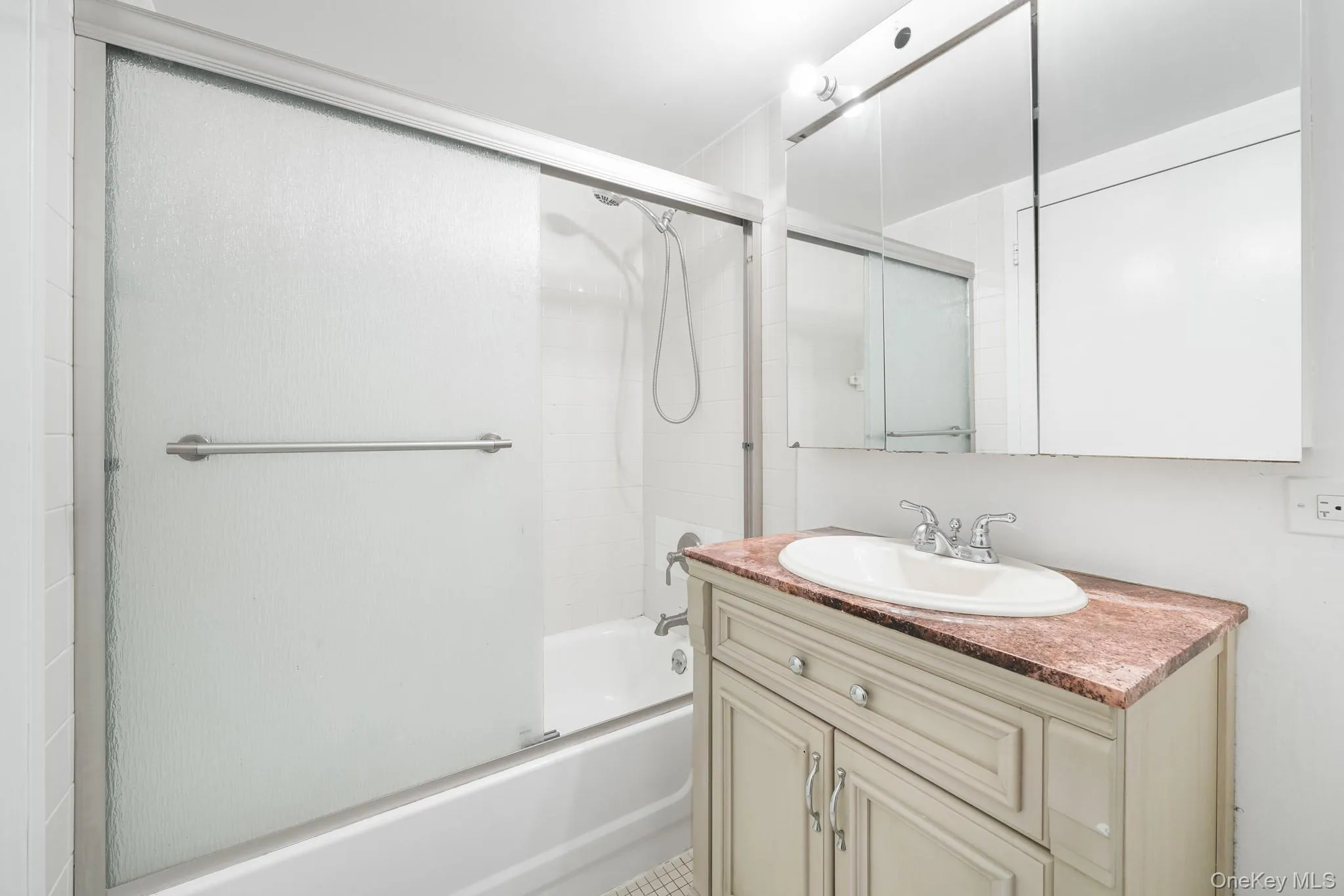 Bathroom featuring bath / shower combo with glass door and vanity Bathroom featuring bath / shower combo with glass door and vanity