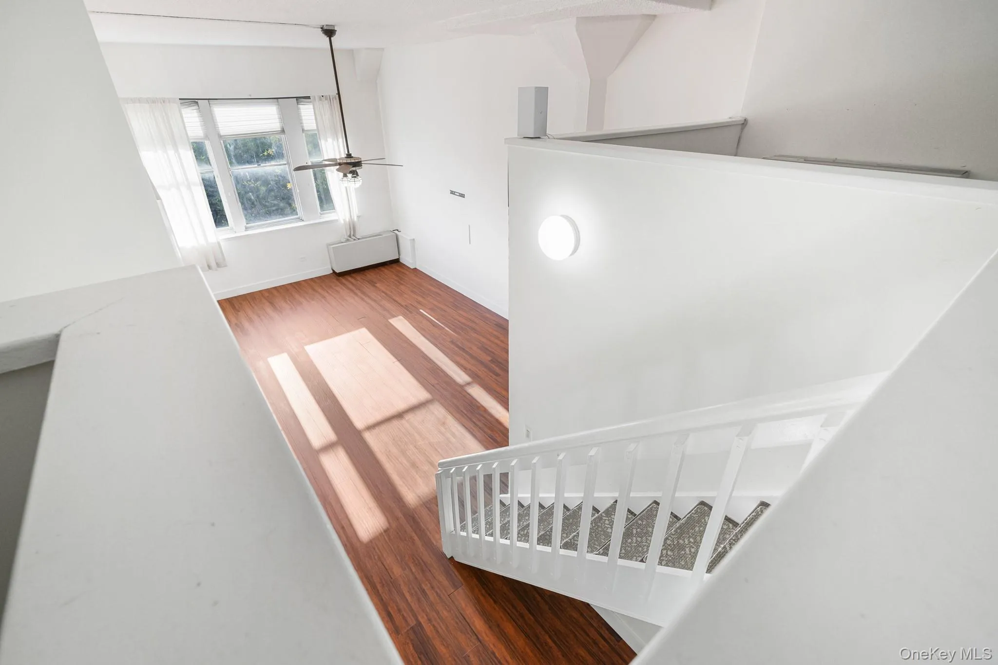 Stairway with wood finished floors and a ceiling fan Stairway with wood finished floors and a ceiling fan