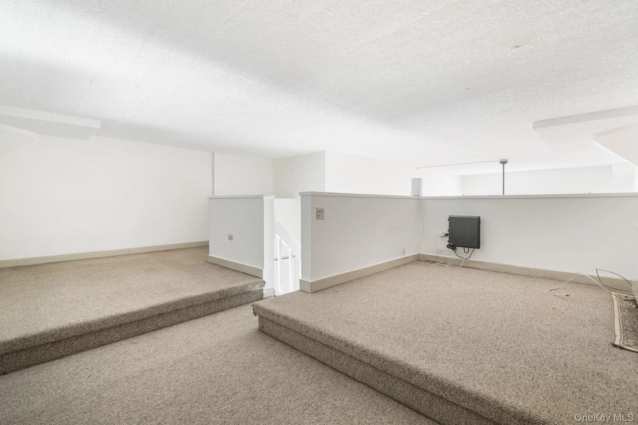 Below grade area featuring carpet flooring and a textured ceiling Below grade area featuring carpet flooring and a textured ceiling