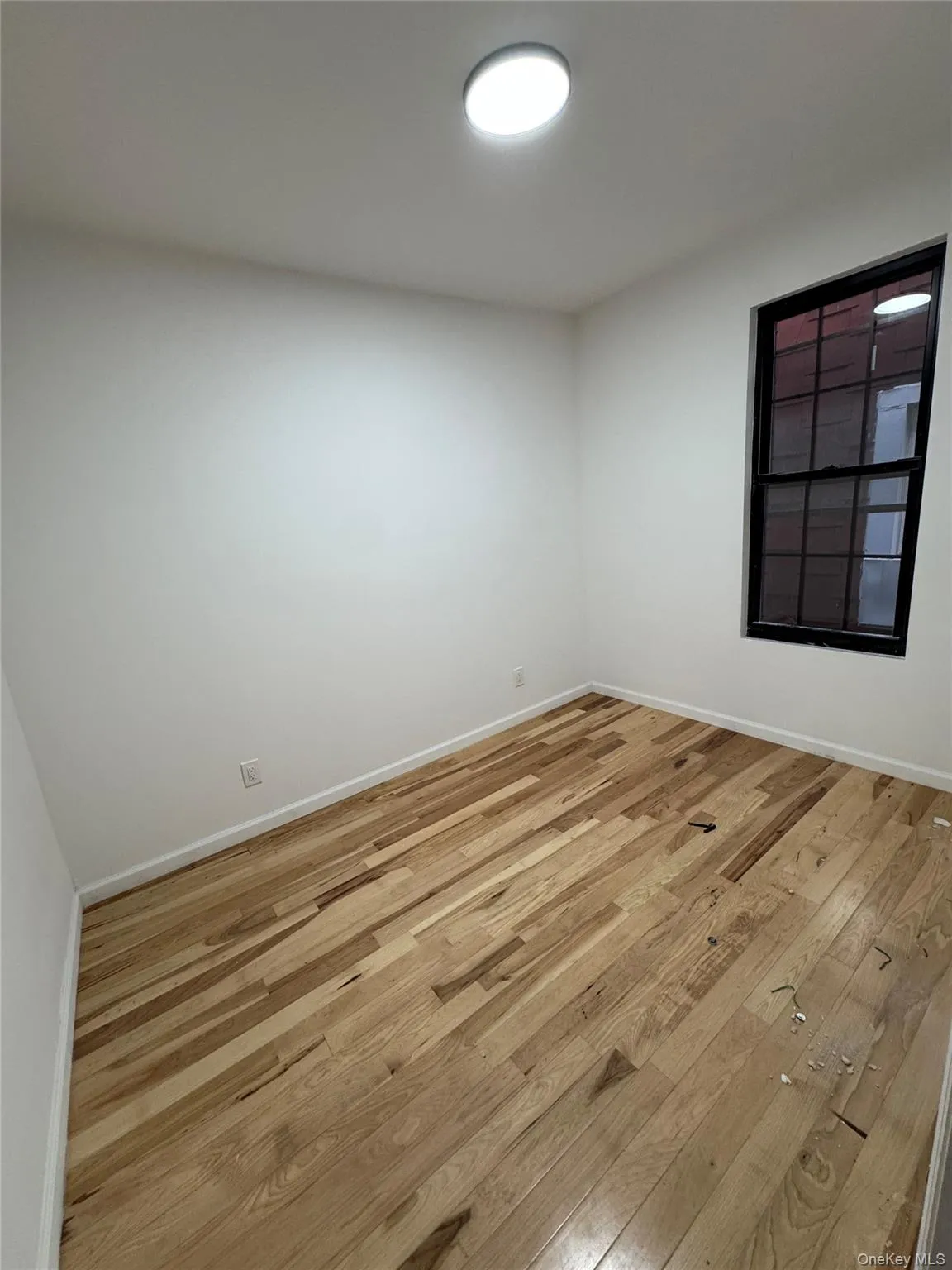 Unfurnished room featuring wood-type flooring and baseboards Unfurnished room featuring wood-type flooring and baseboards